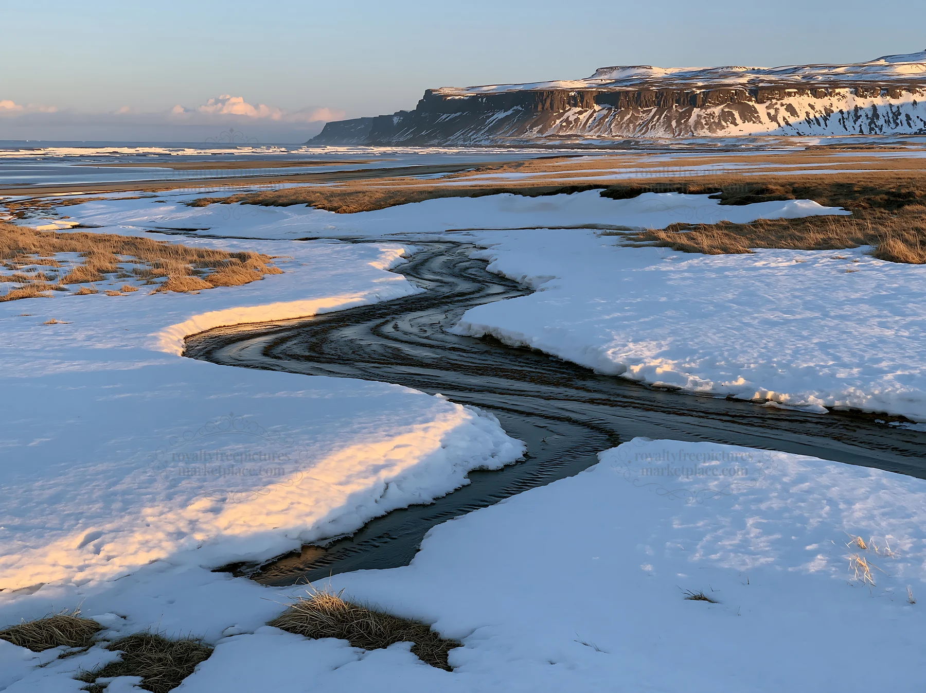 Snowbound meadow with stream and cliffs in winter light - AI-generated stock image