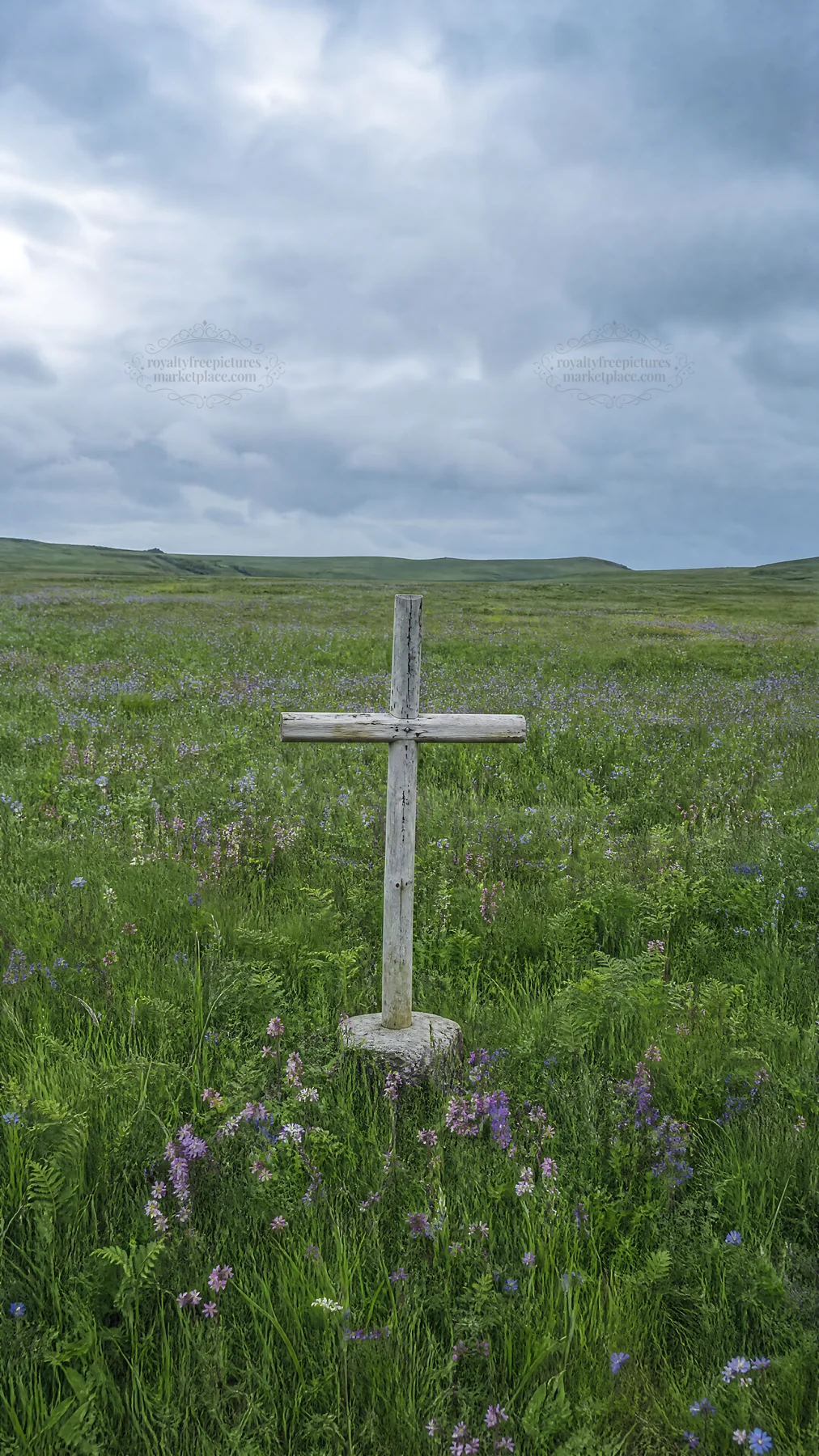 Rustic Christian cross in spring meadow under cloudy sky - AI-generated stock image