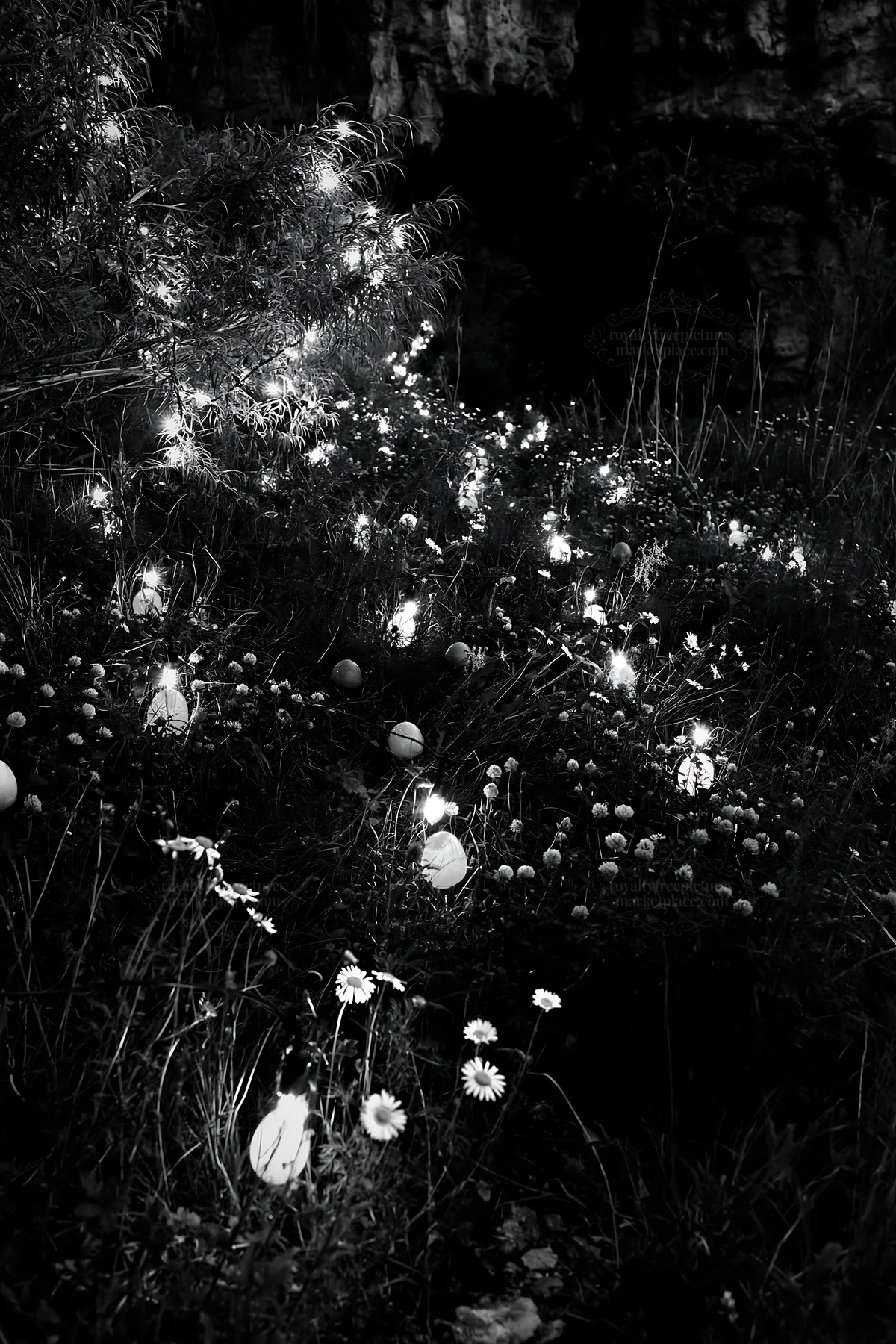 Christmas lanterns at dusk in meadow near cave - AI-generated stock image