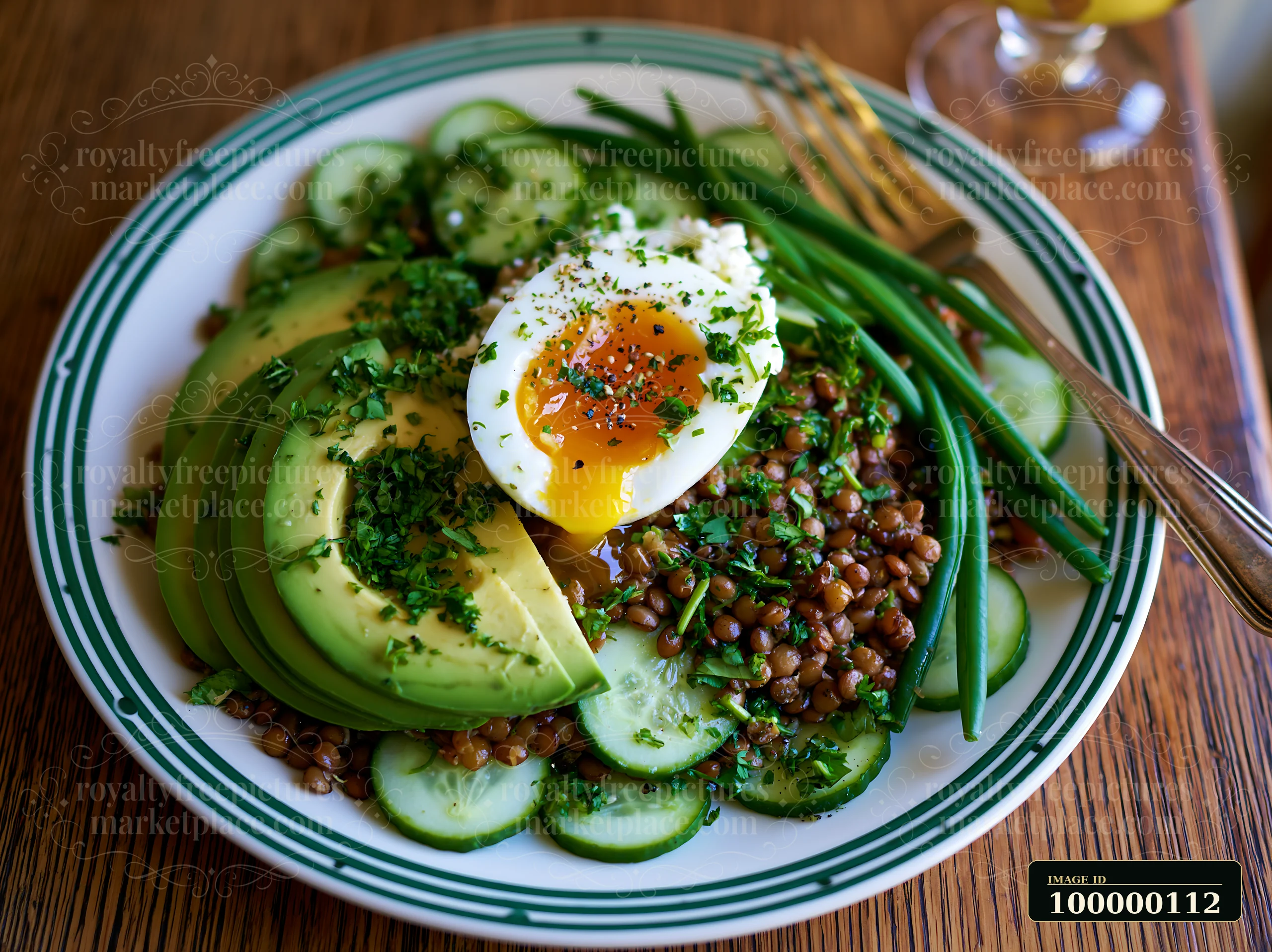 Close-up of a lentil salad plate with avocado, cucumber, green beans, herbs, and a soft-cooked egg.