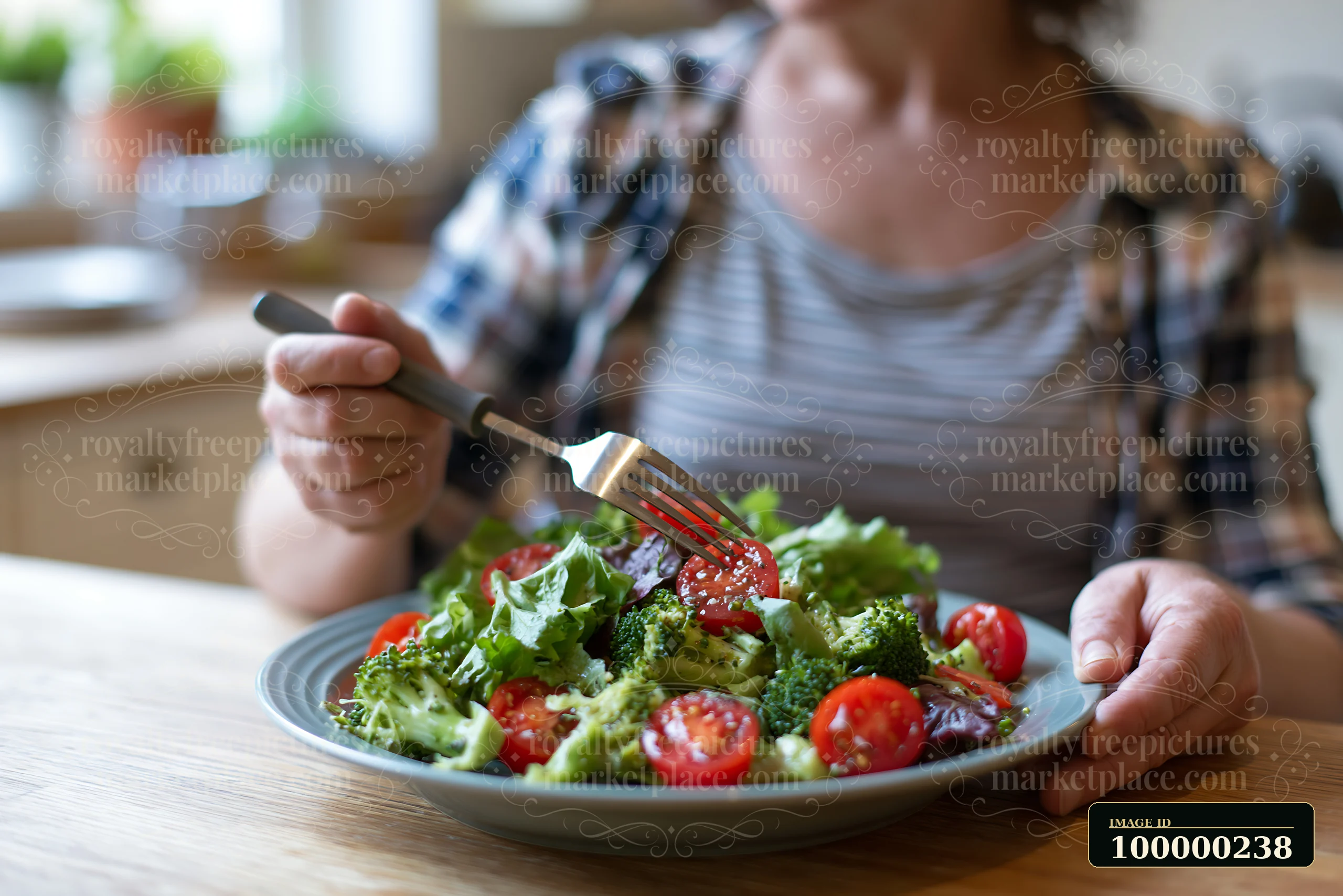 Person holding a fork over a fresh vegetable salad at a dining table.