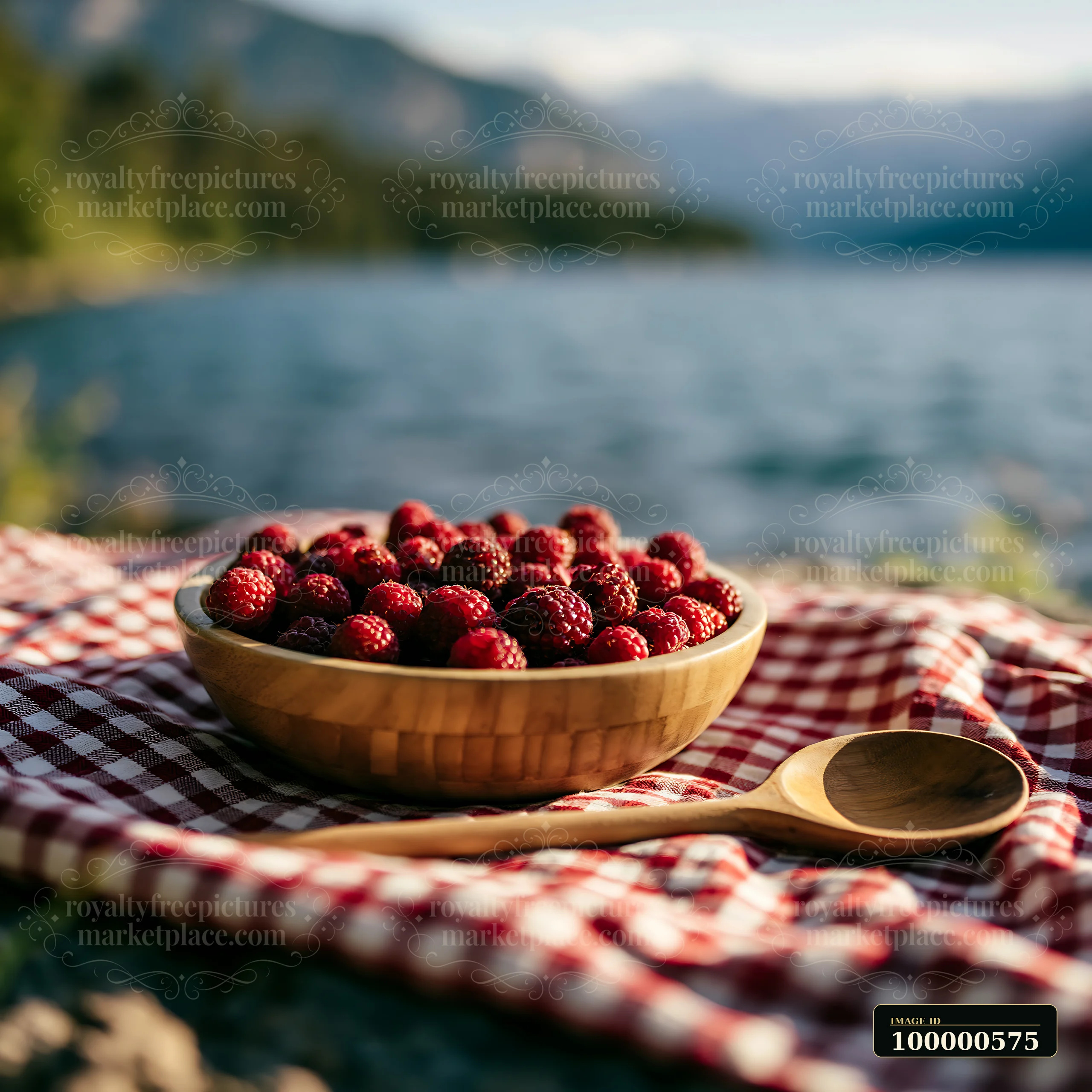 A bowl of fresh raspberries rests on a red and white checkered cloth by a clear alpine lake.