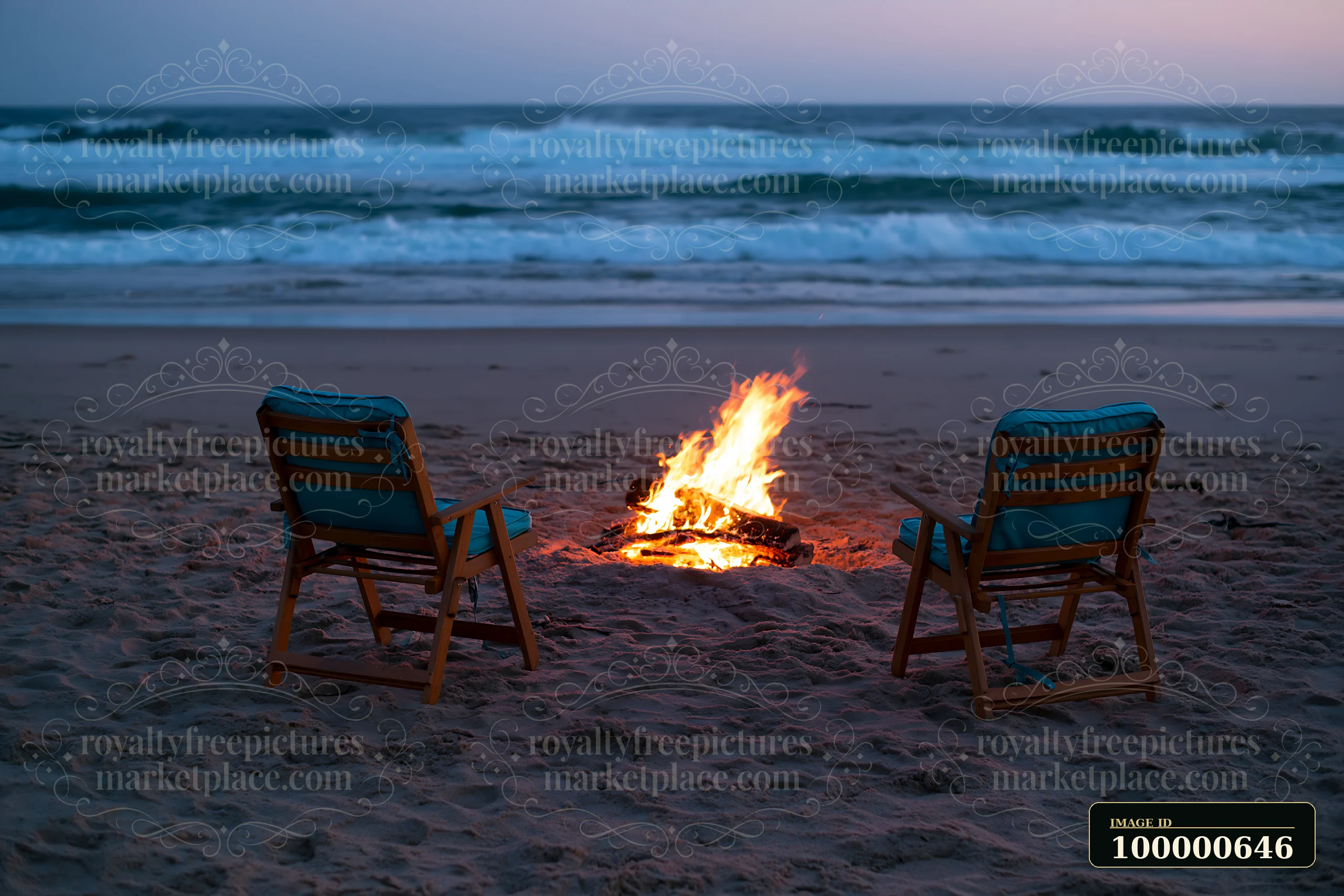 Two chairs are placed near a bonfire on the sandy beach as waves crash against the shore.