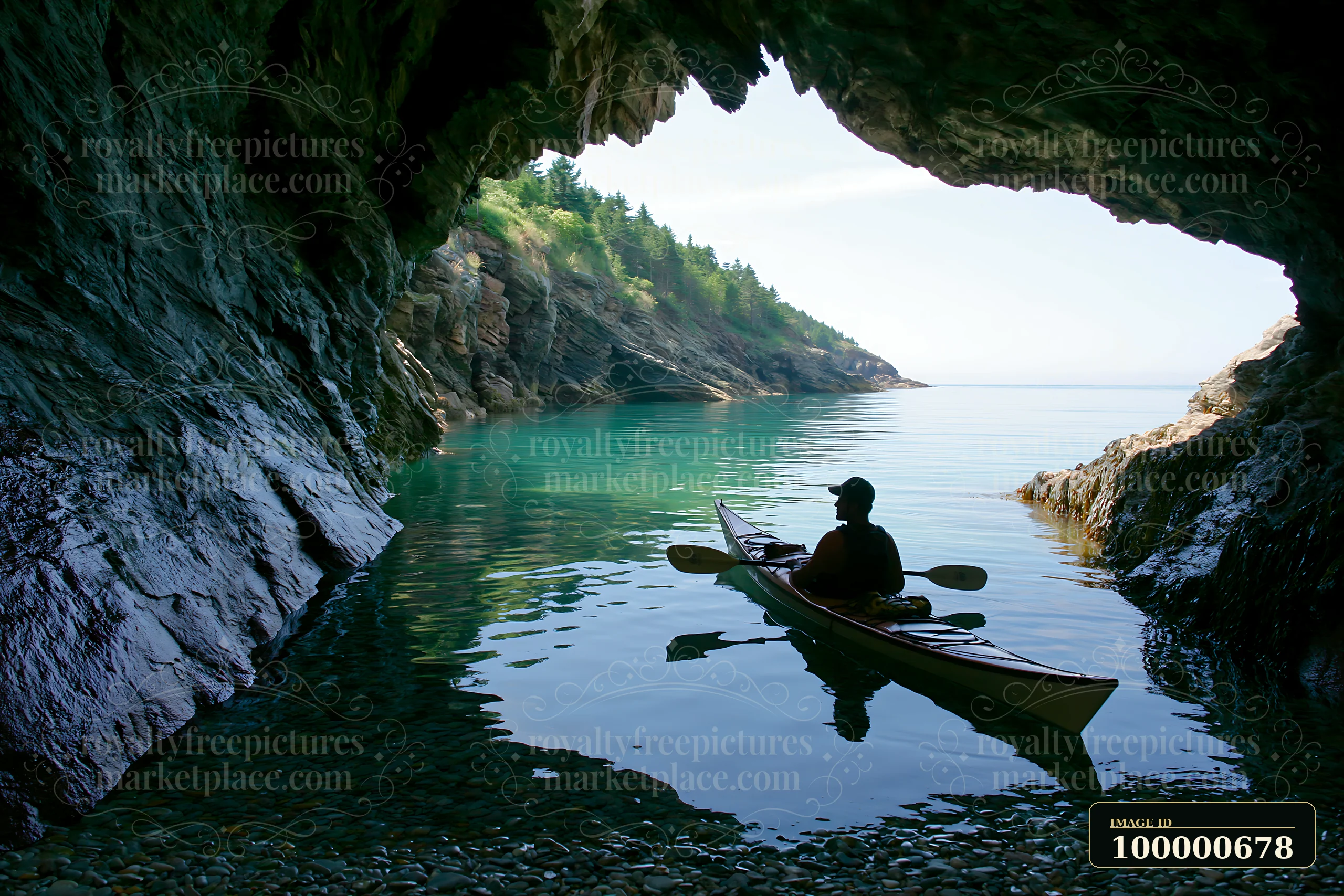 A person in a kayak paddles through a rocky cave along a coastline covered in sea fog, surrounded by calm waters and lush greenery.