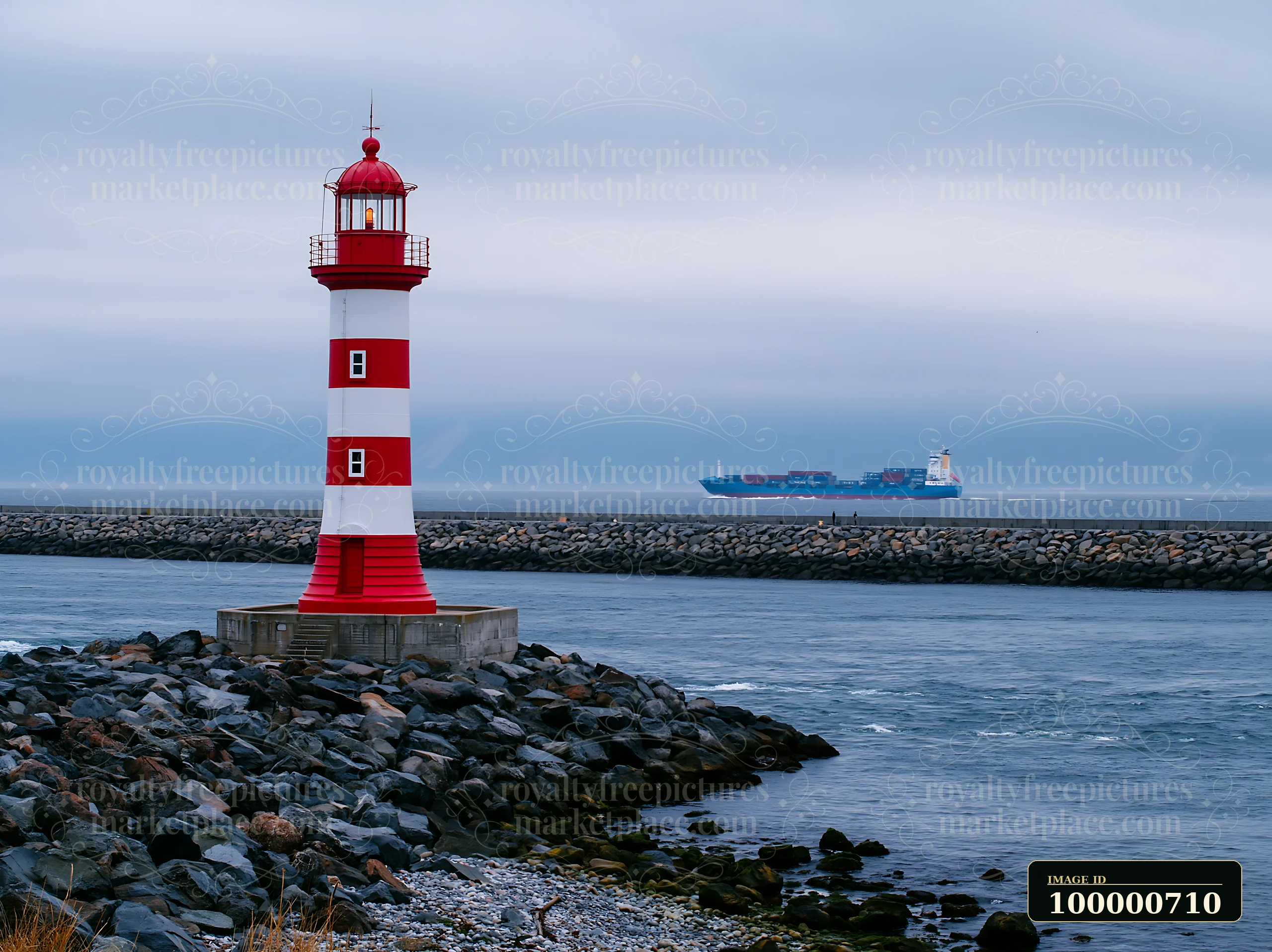A red and white lighthouse stands near a rocky shoreline in a foggy coastal setting.