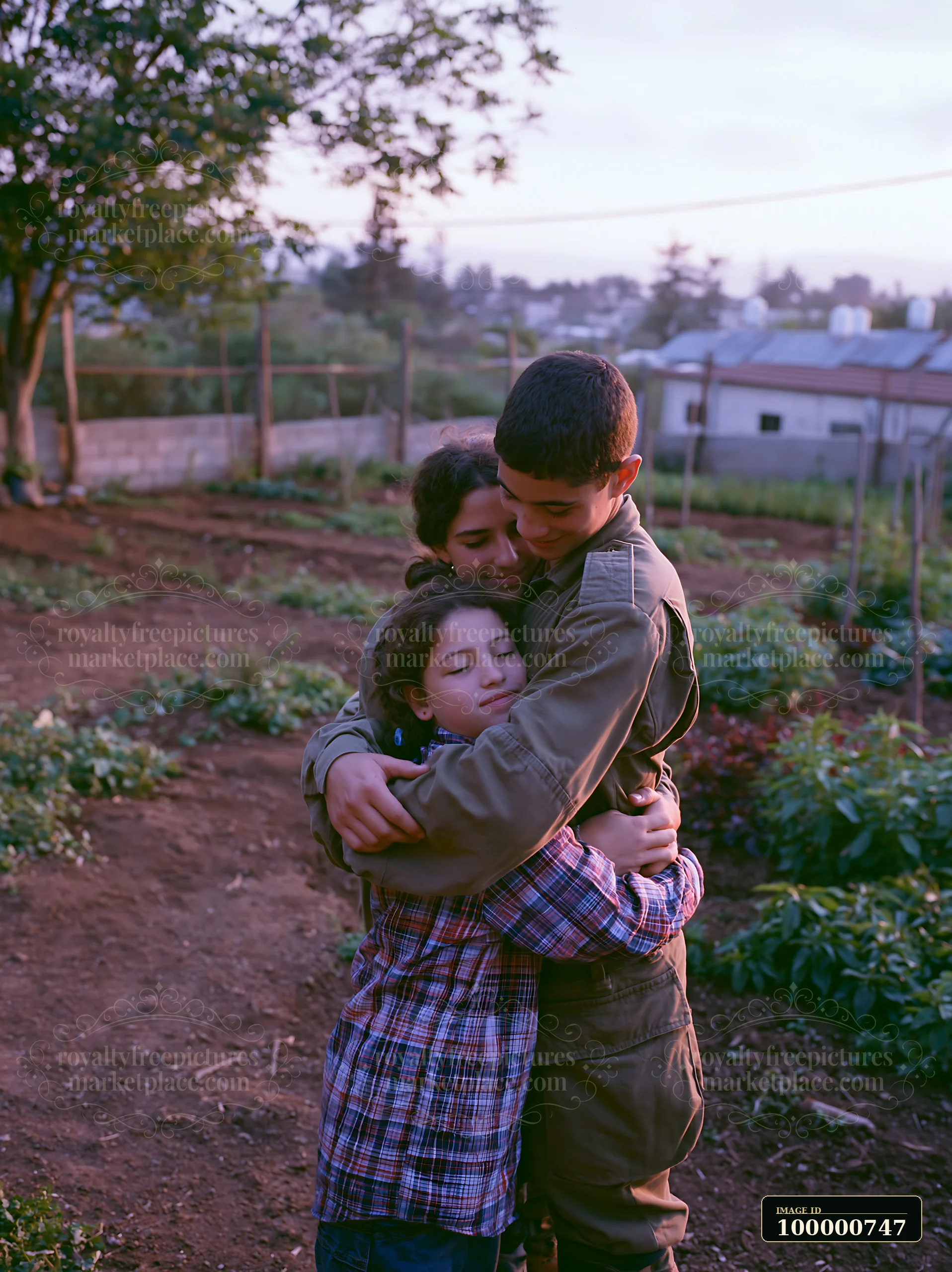 Two children hug a third child in a garden surrounded by plants.