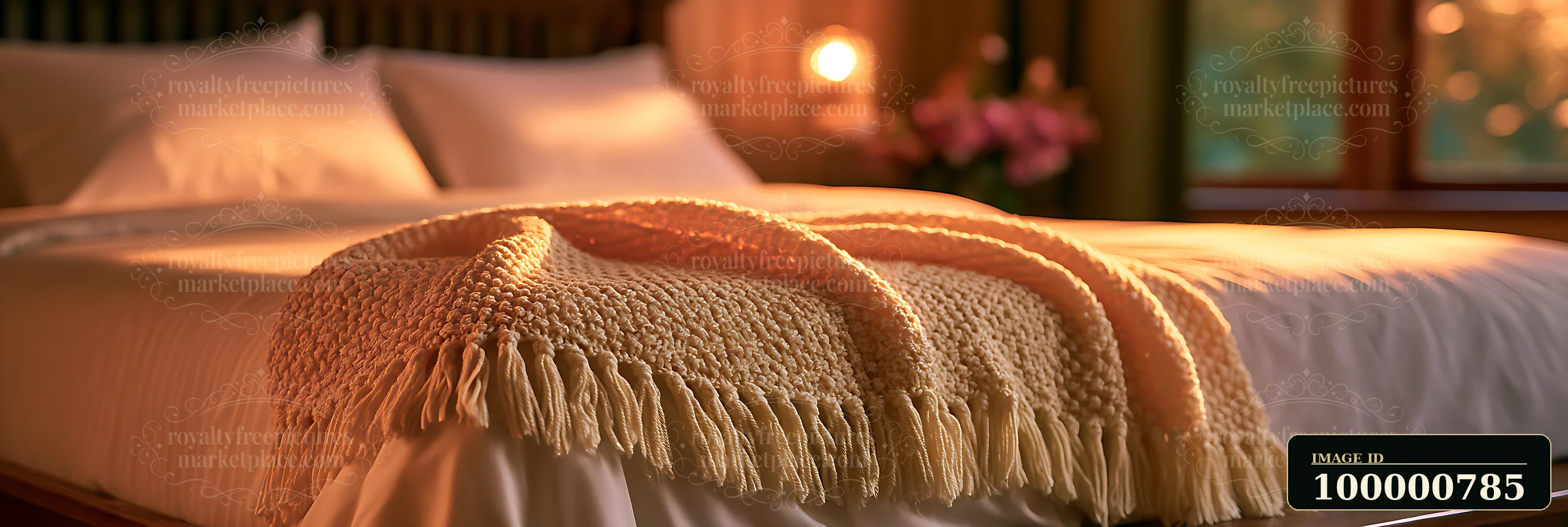 A bedroom features a neatly made bed with a knitted blanket draped across the edge.