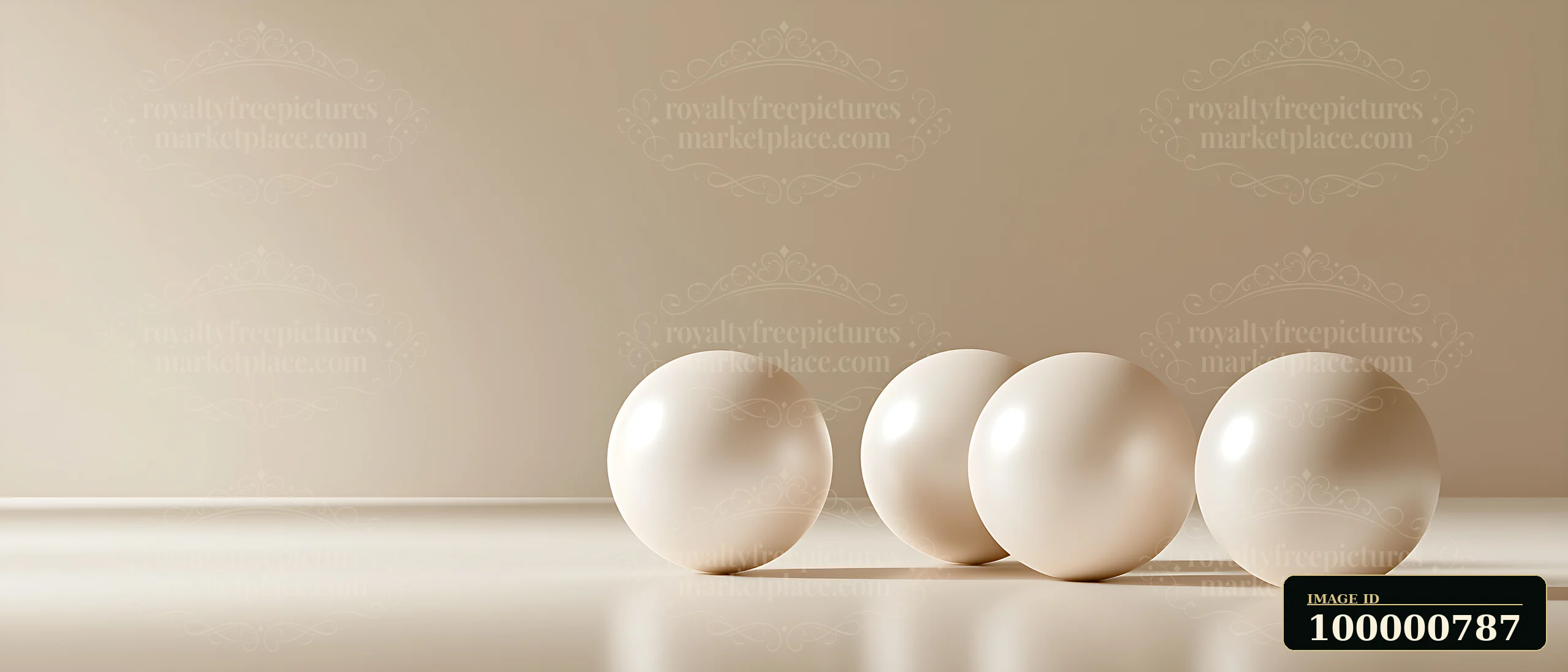 Four smooth white spheres rest in a row on a flat surface against a neutral background.