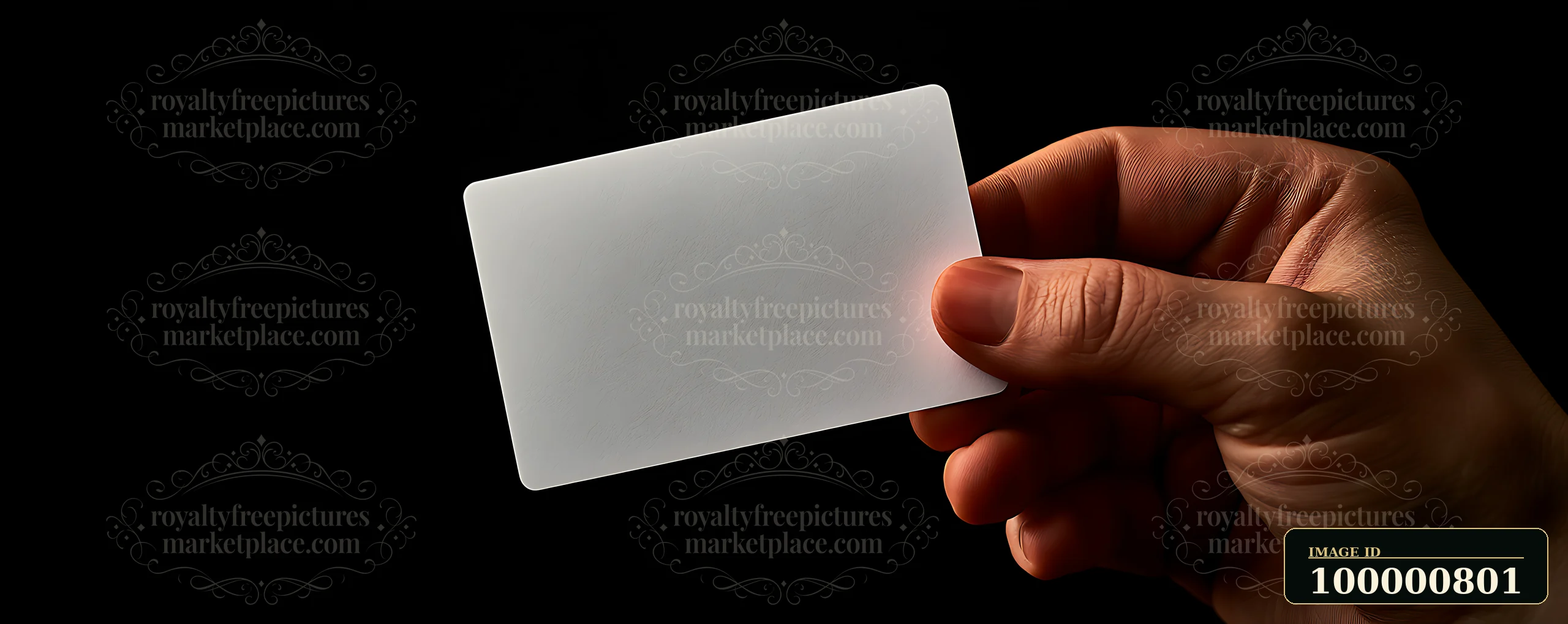 A person holds a plain white card in their hand with a dark background.