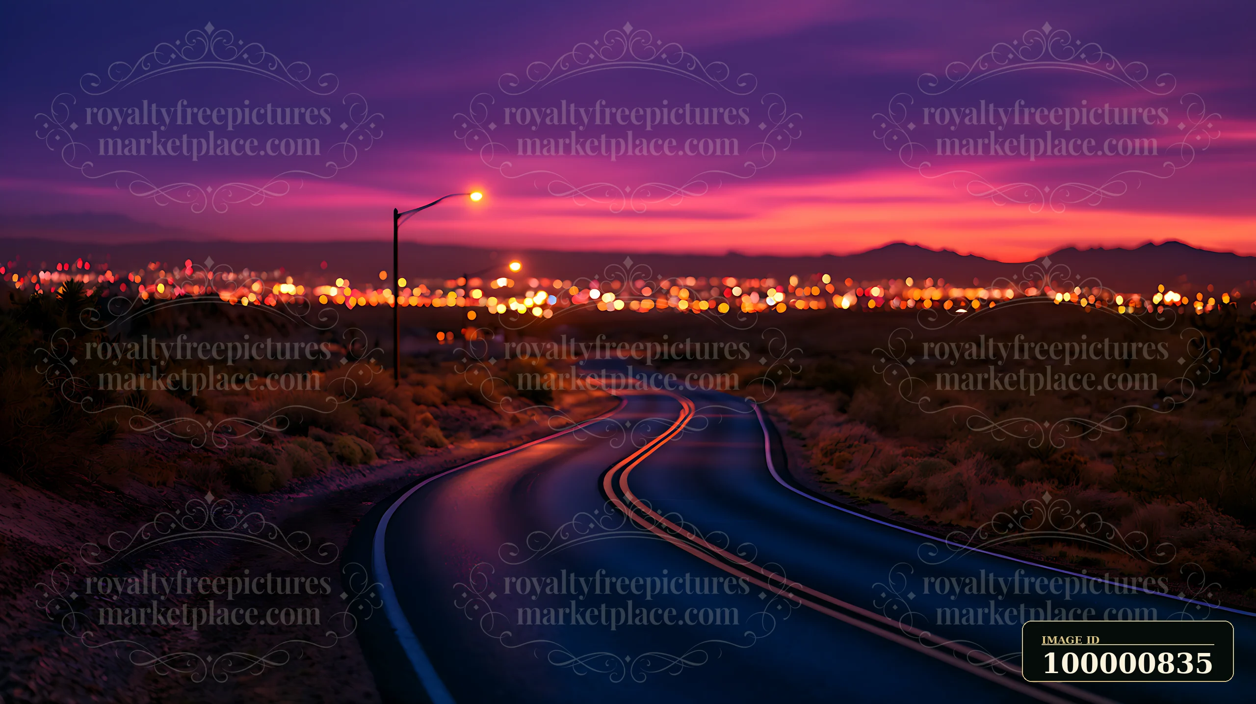A winding road leads through a desert landscape under a twilight sky.