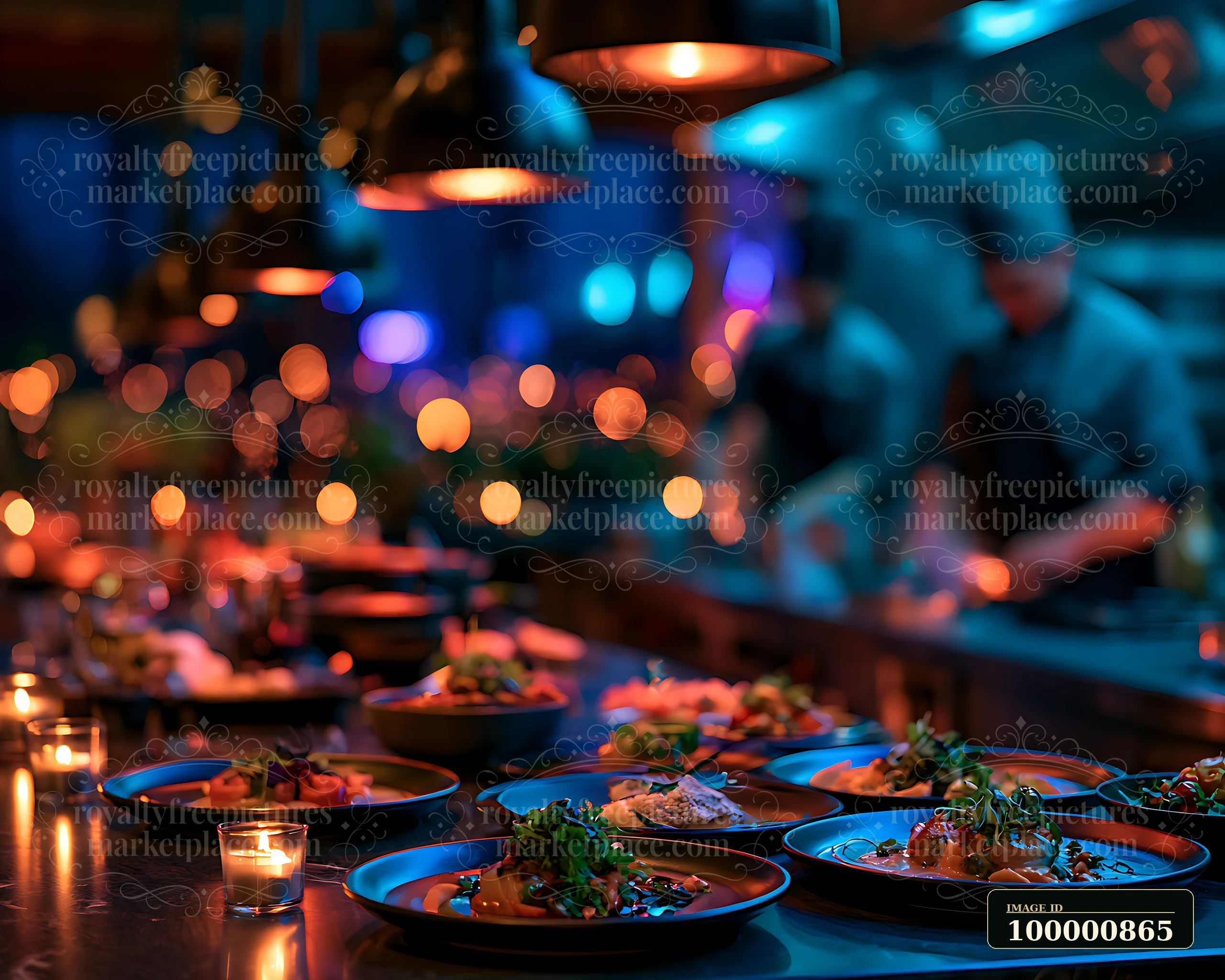 Several plates of gourmet food are arranged on a table in a stylish kitchen.
