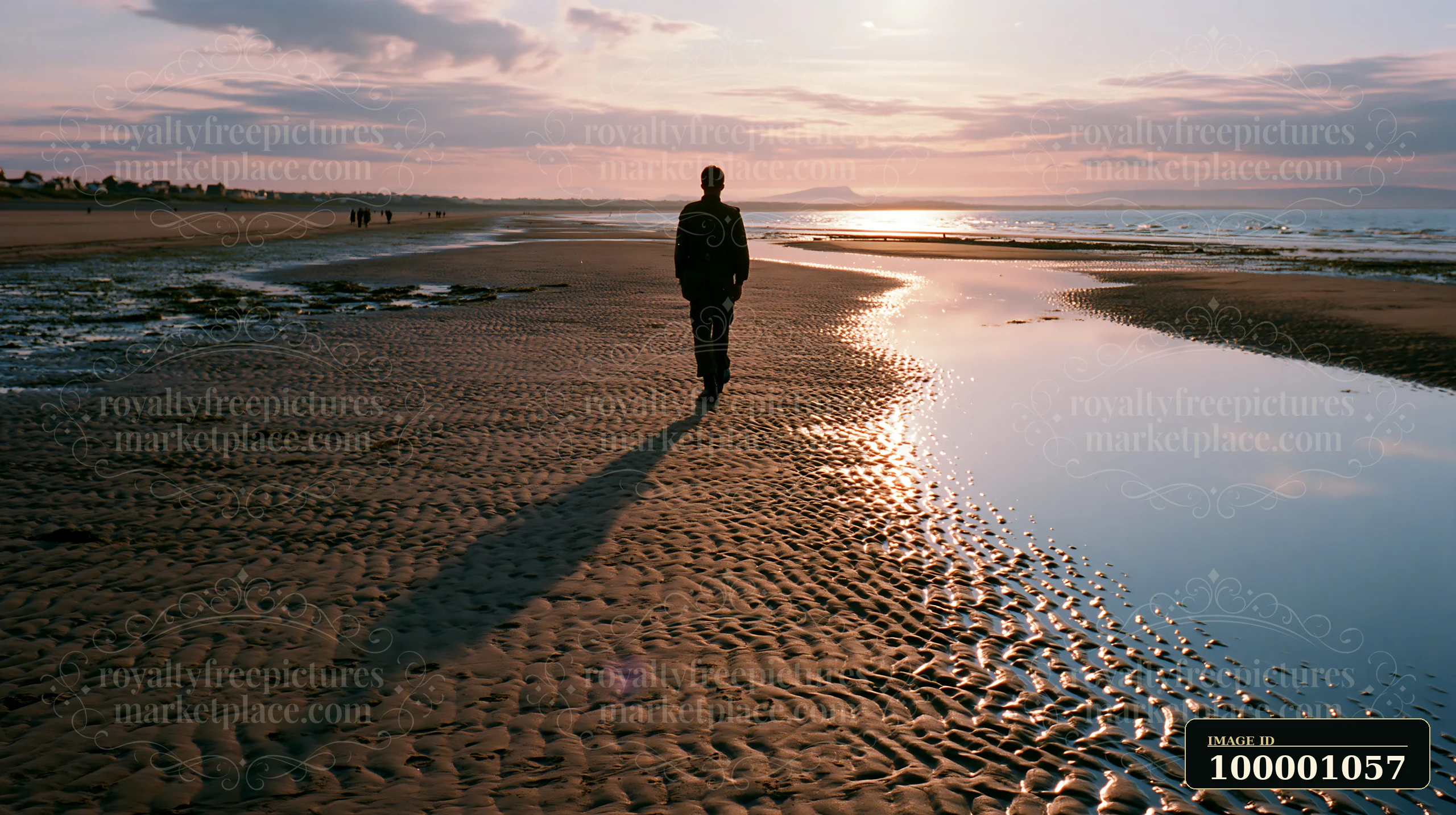 A soldier walks along the wet sand of a beach during sunset.