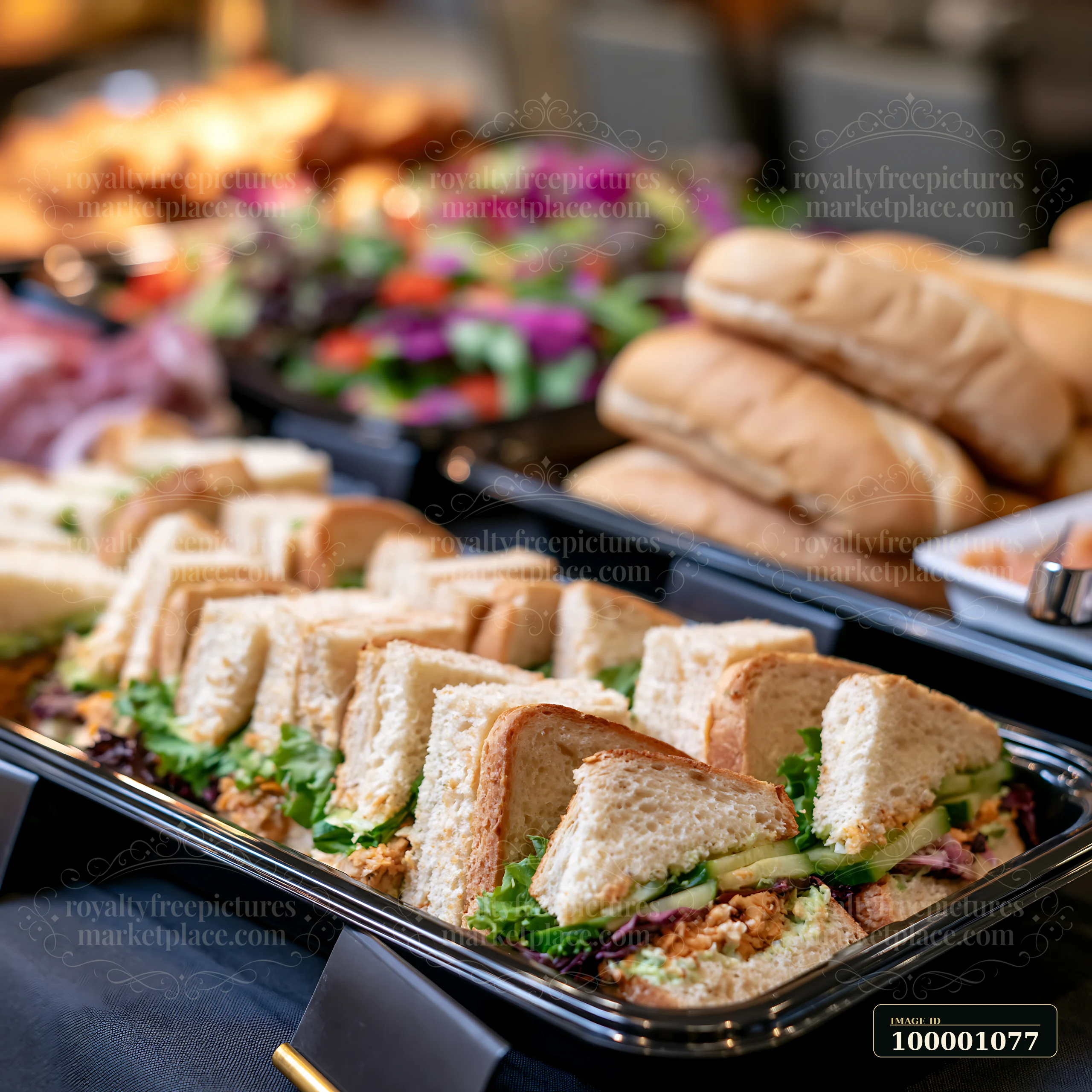 A buffet setup at a business conference features neatly arranged sandwiches and rolls.