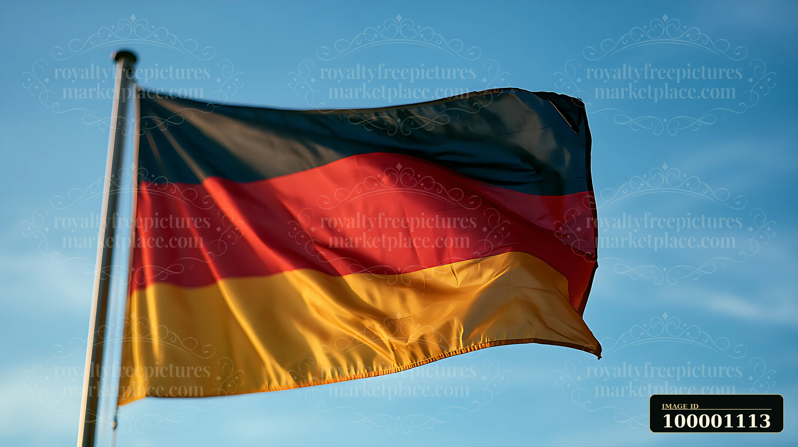 A German flag is flying high on a flagpole with a clear blue sky in the background.