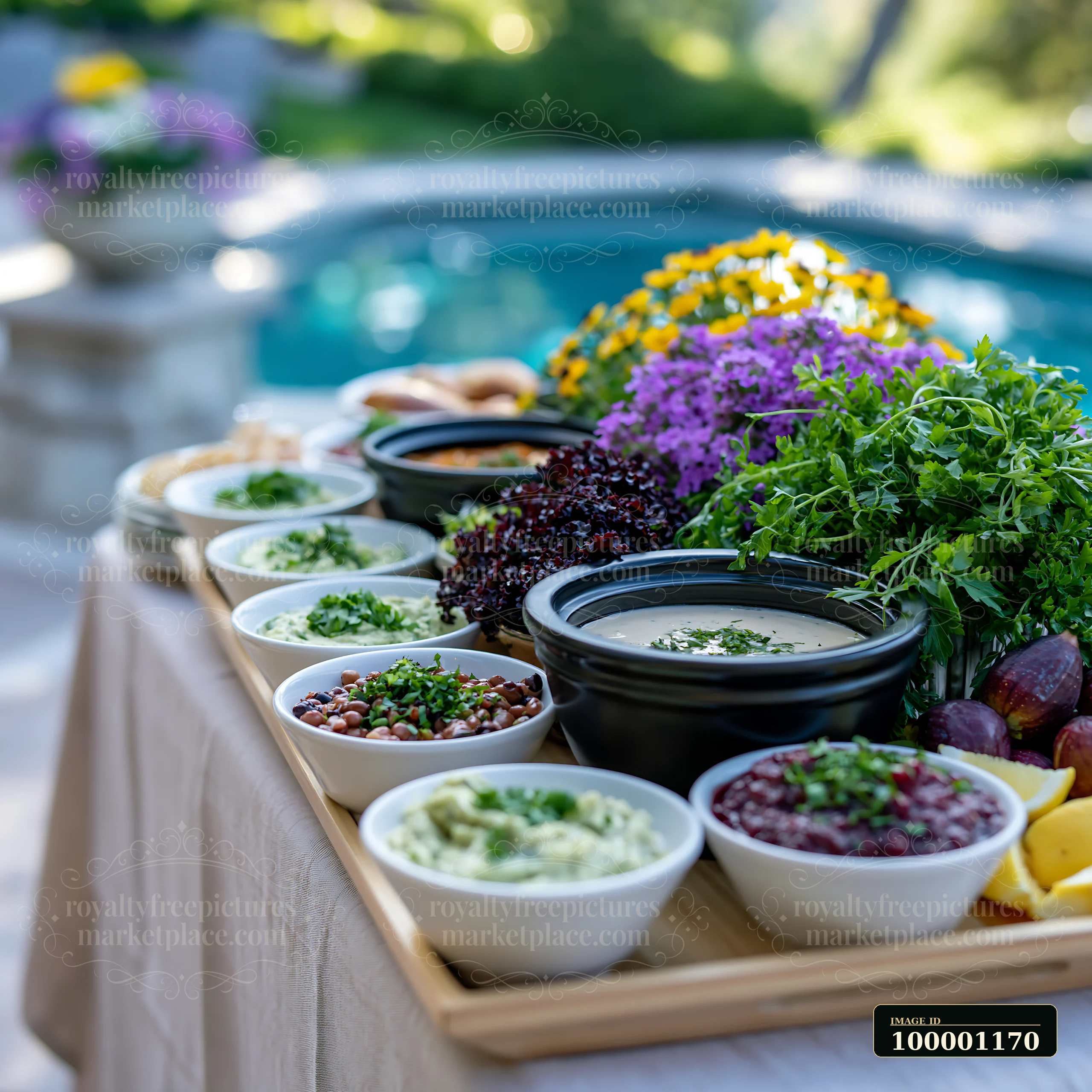 The setup features a poolside buffet table with an assortment of bowls filled with dips and toppings.