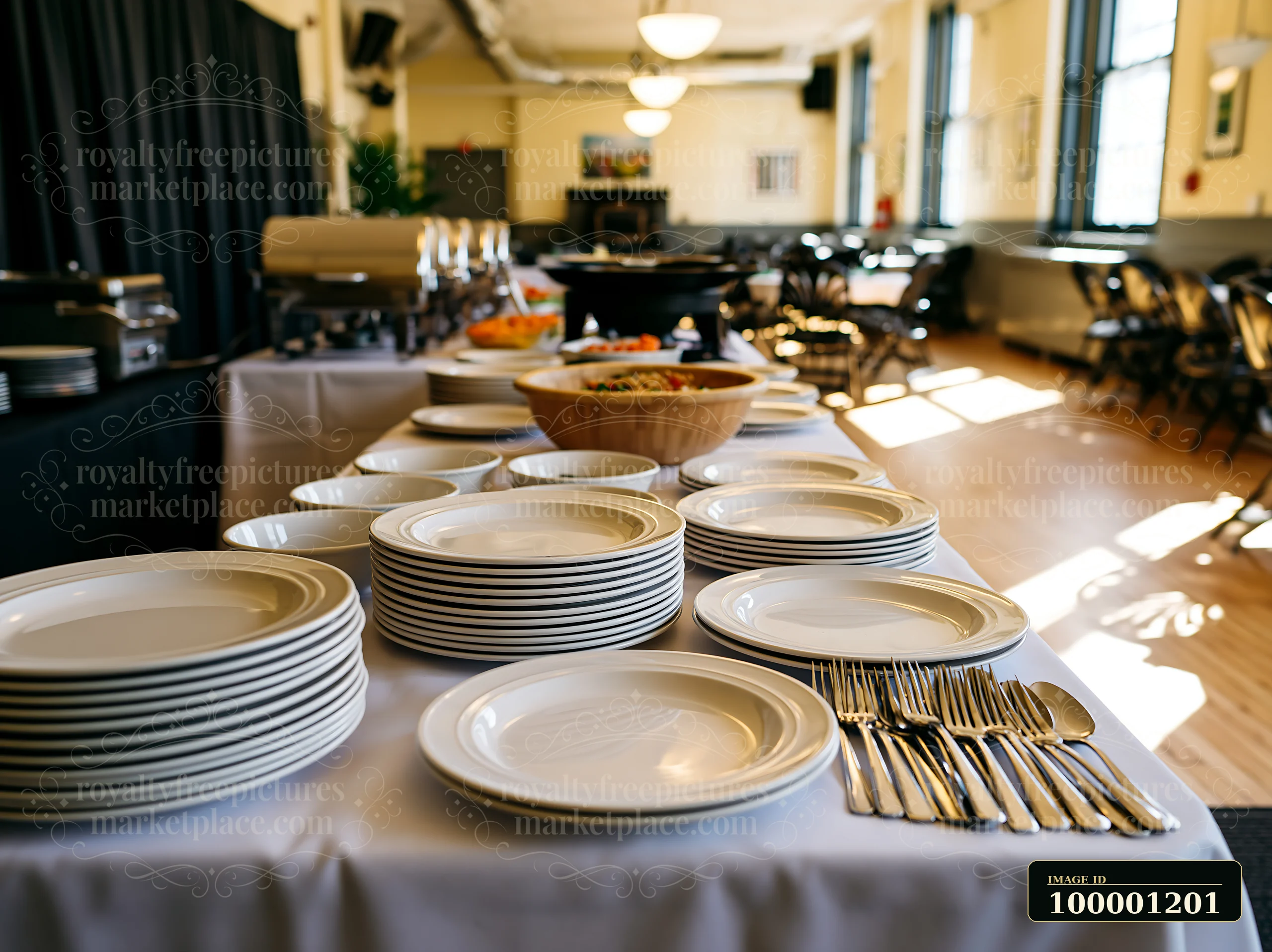 A table is set with neatly arranged plates and silverware in a dining room.