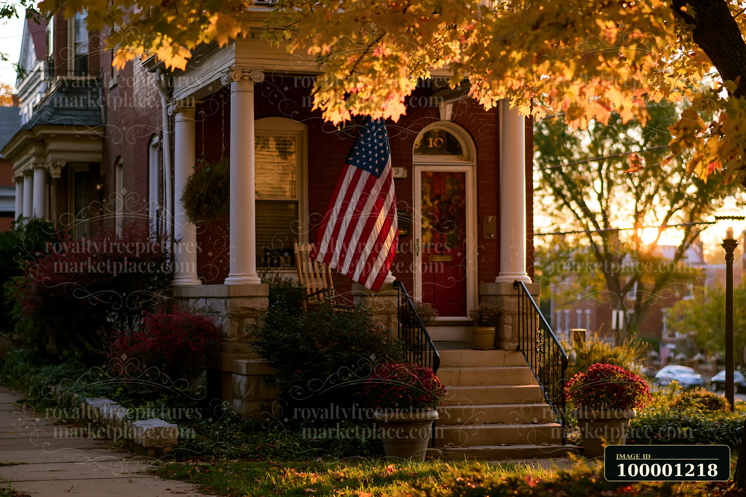 An American flag hanging from a porch adds character to a home during autumn.