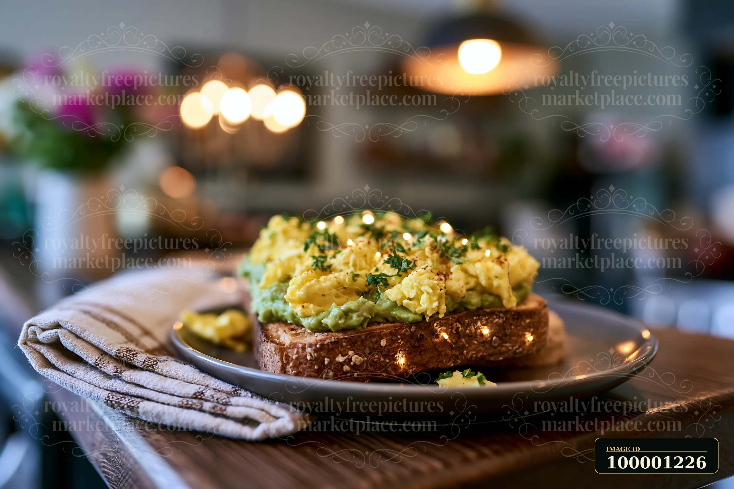 A breakfast plate with avocado toast topped with scrambled eggs sits on a wooden table in a café.