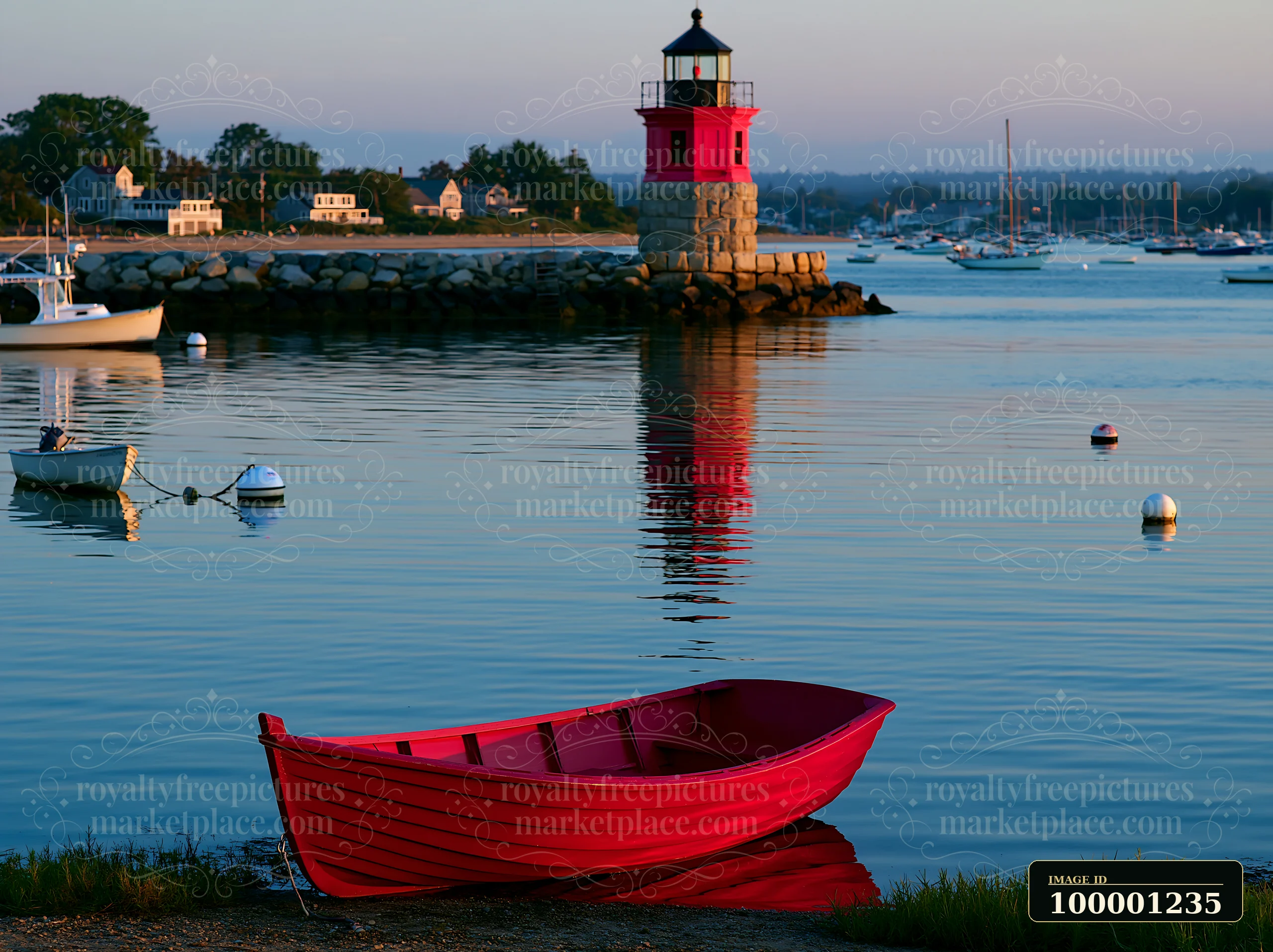A red boat is anchored near a lighthouse with boats in the background.