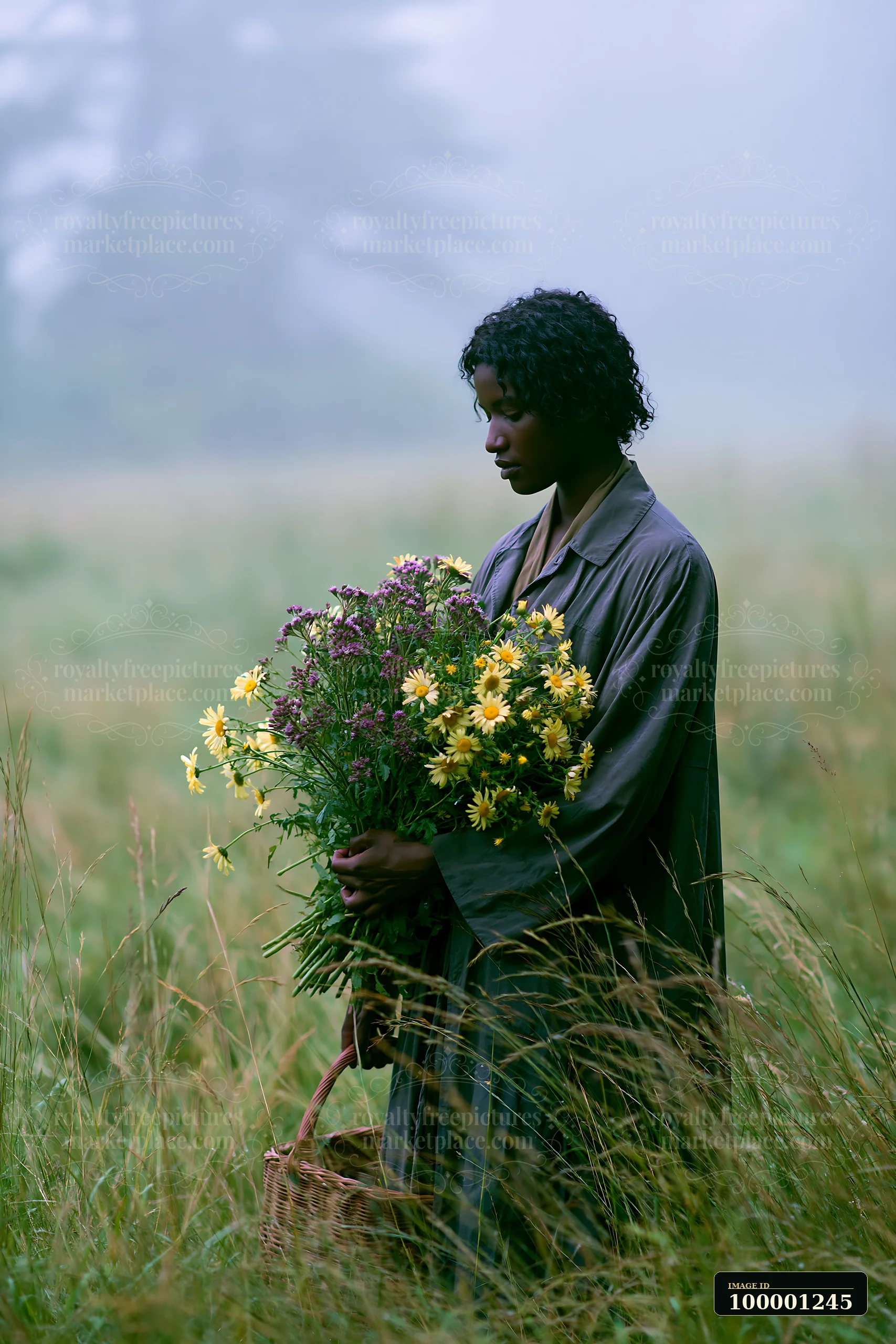 A person stands in a meadow in morning mist, holding a large bouquet of wildflowers.
