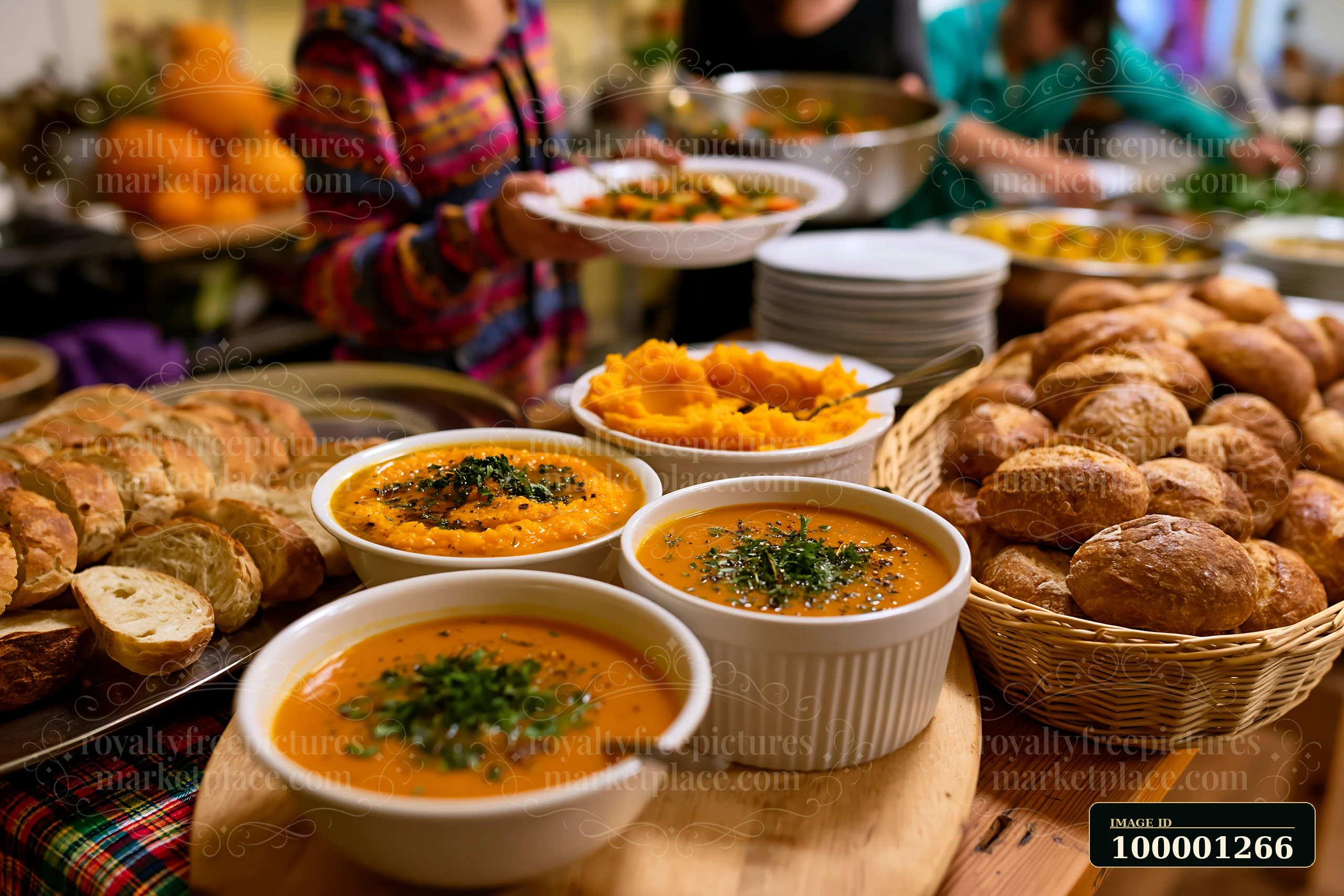 A table is filled with various dishes including soups, bread, and salads during a buffet catering event.