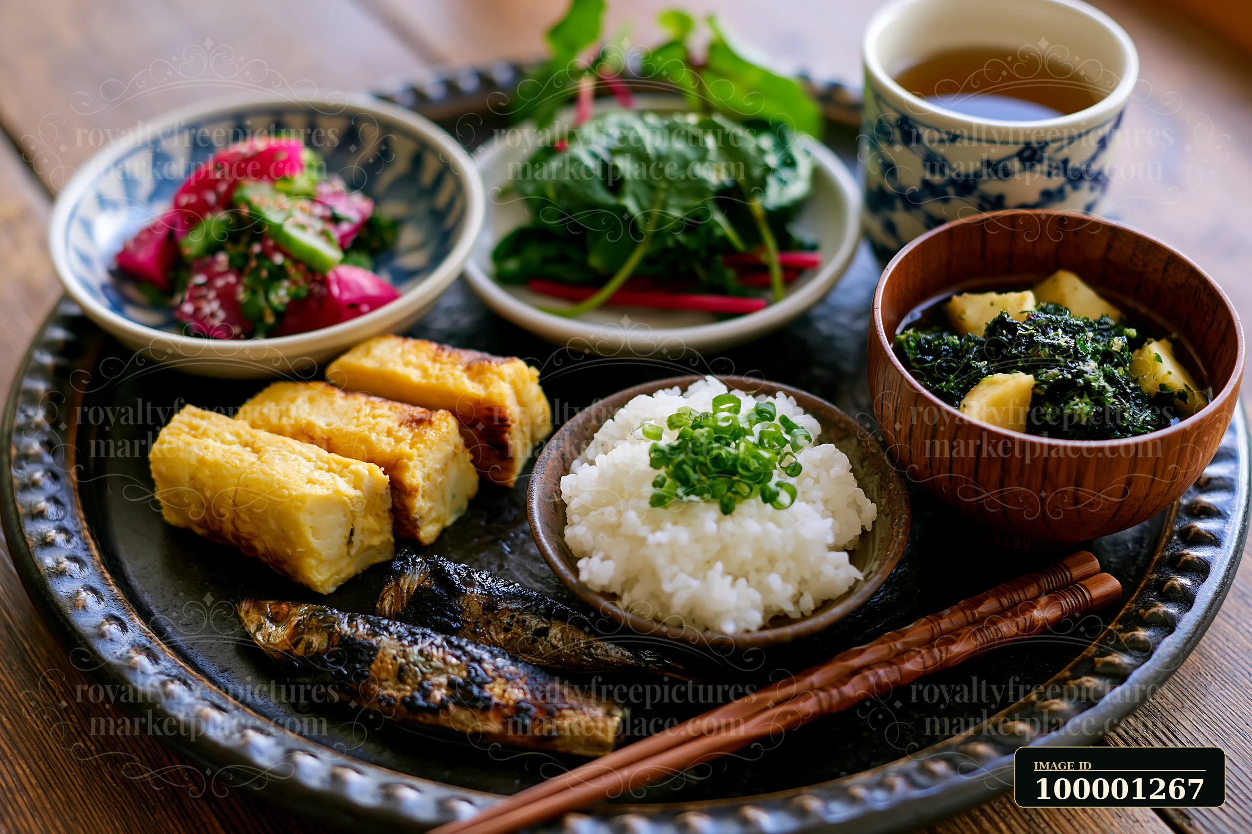 A breakfast plate with Japanese breakfast includes rice, grilled fish, pickled vegetables, and greens.