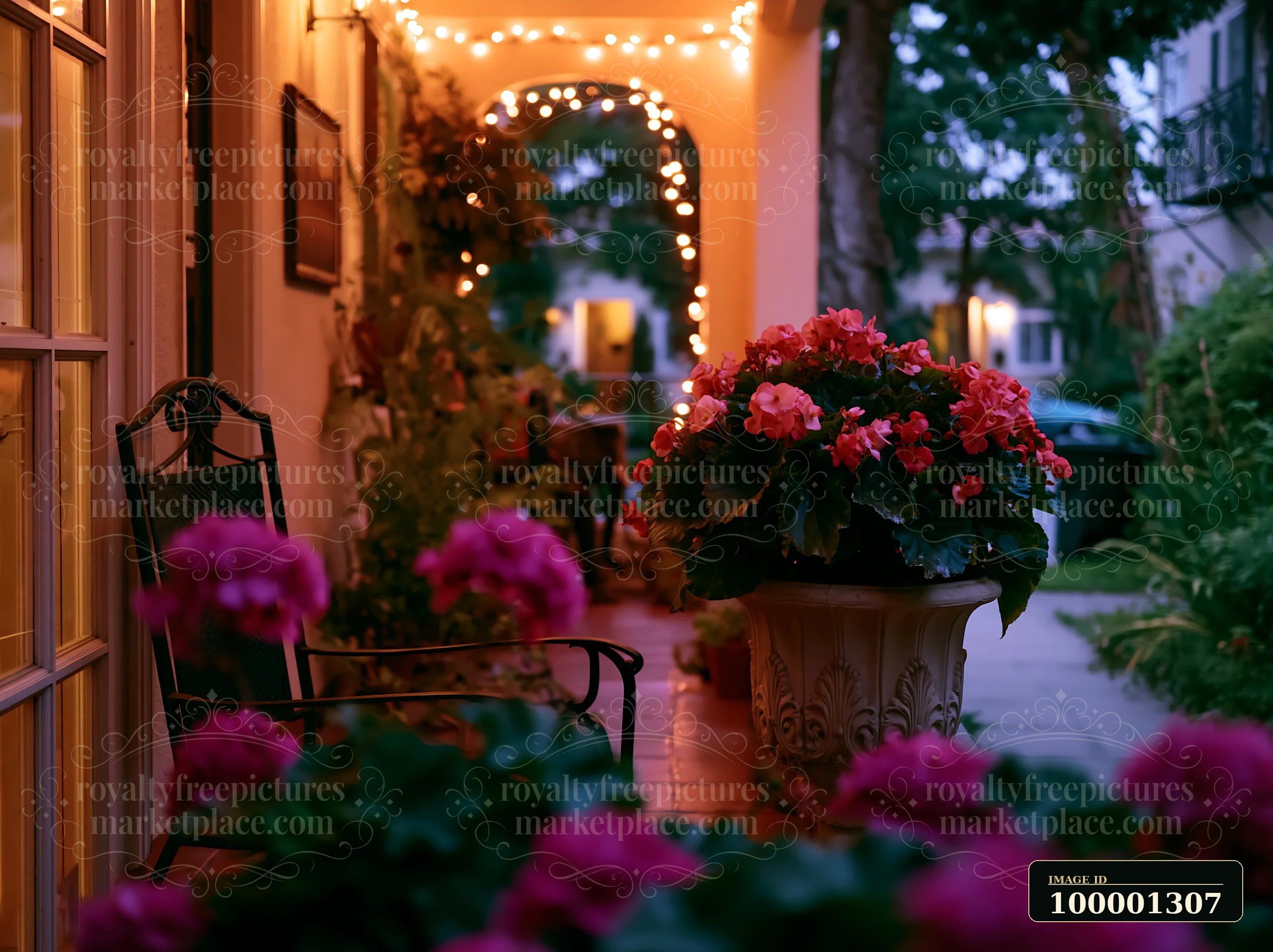 Begonia flowers on balcony surround a cozy walkway lit by string lights in the evening.