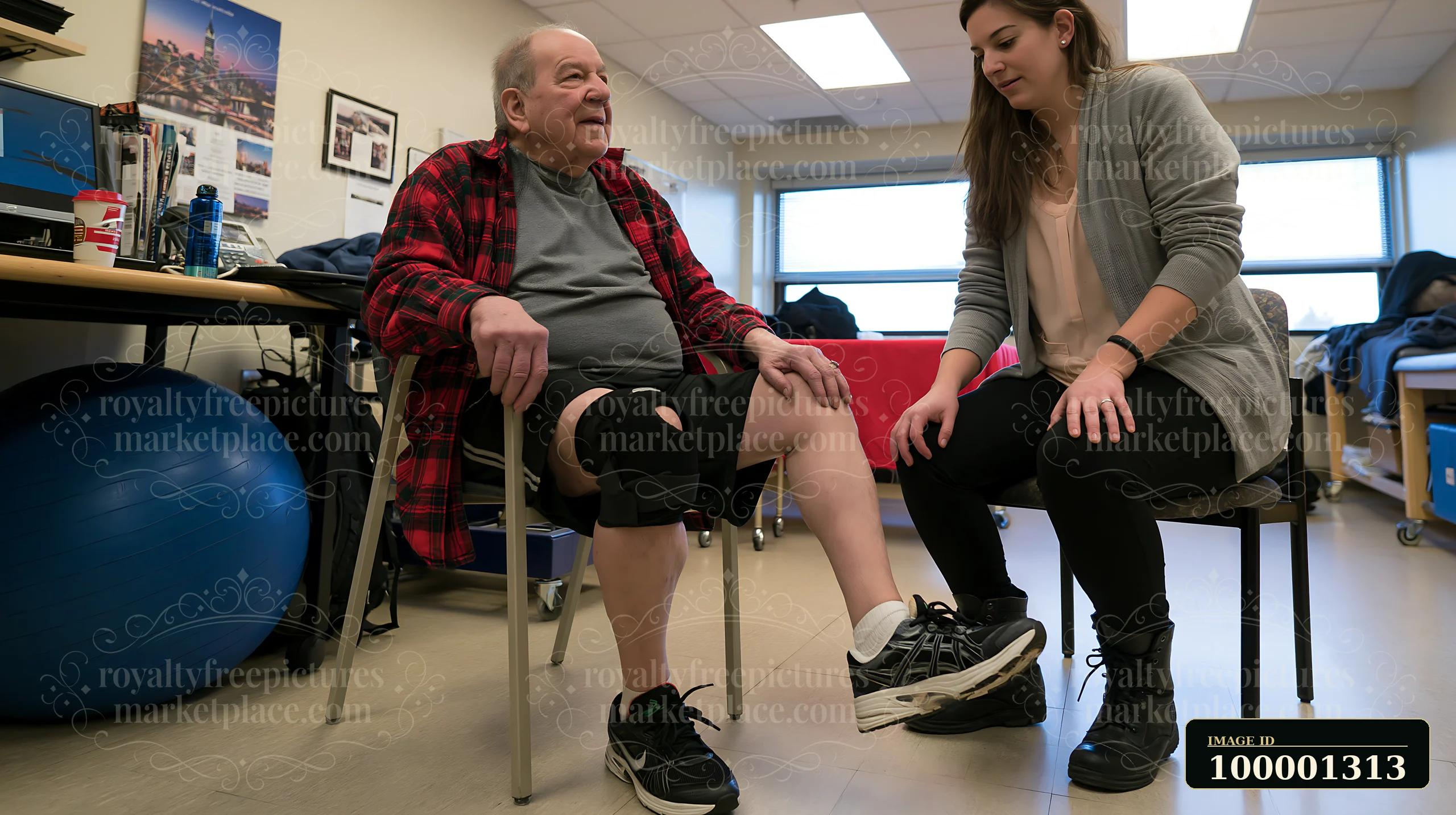 A person with Parkinson's disease receiving support sits in a chair while a caregiver assists with leg exercises in a therapy room.