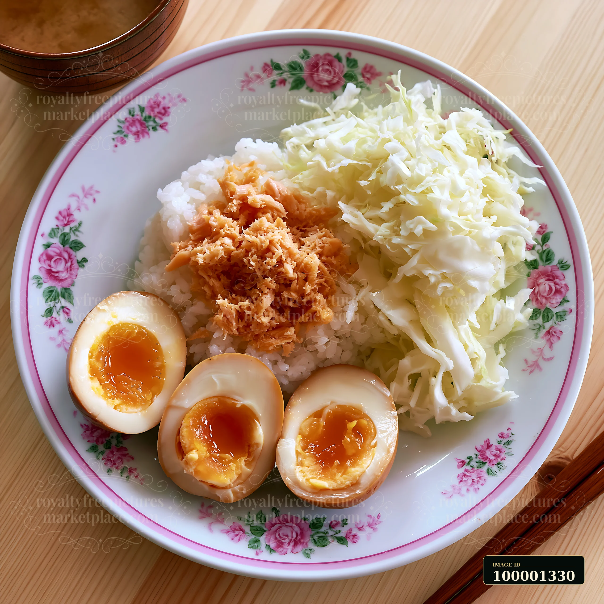 A breakfast plate with Japanese breakfast is served on a floral dish.