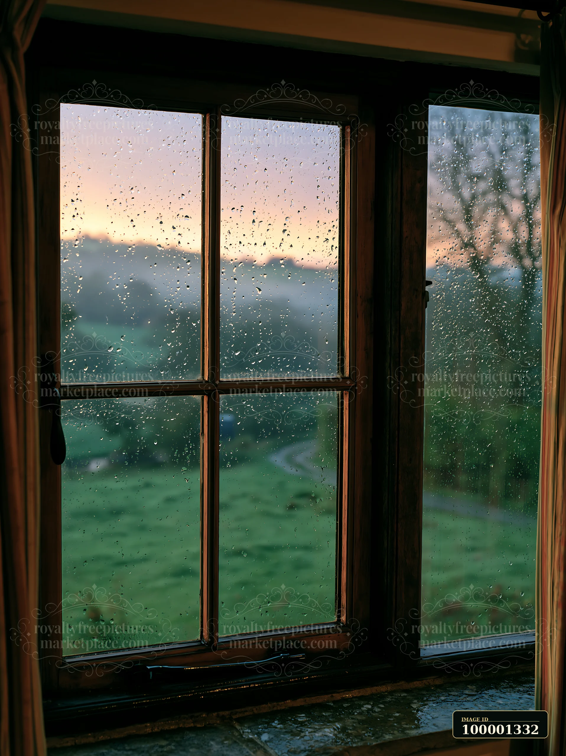 Raindrops cover the window as dawn breaks over the misty countryside around cottage.