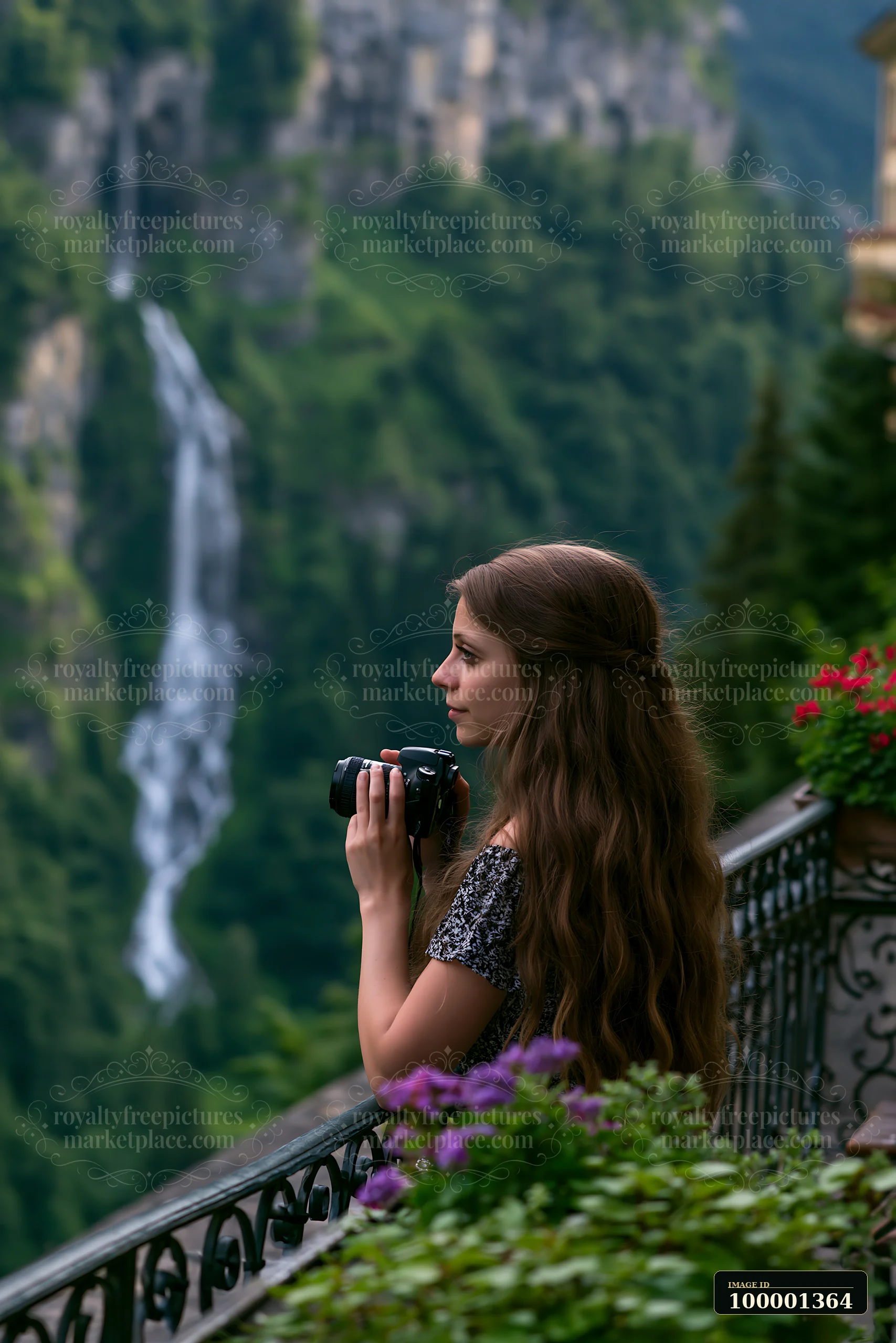 A woman stands on a balcony of a Swiss mountain hotel, taking photographs of the stunning landscape and waterfall in the background.