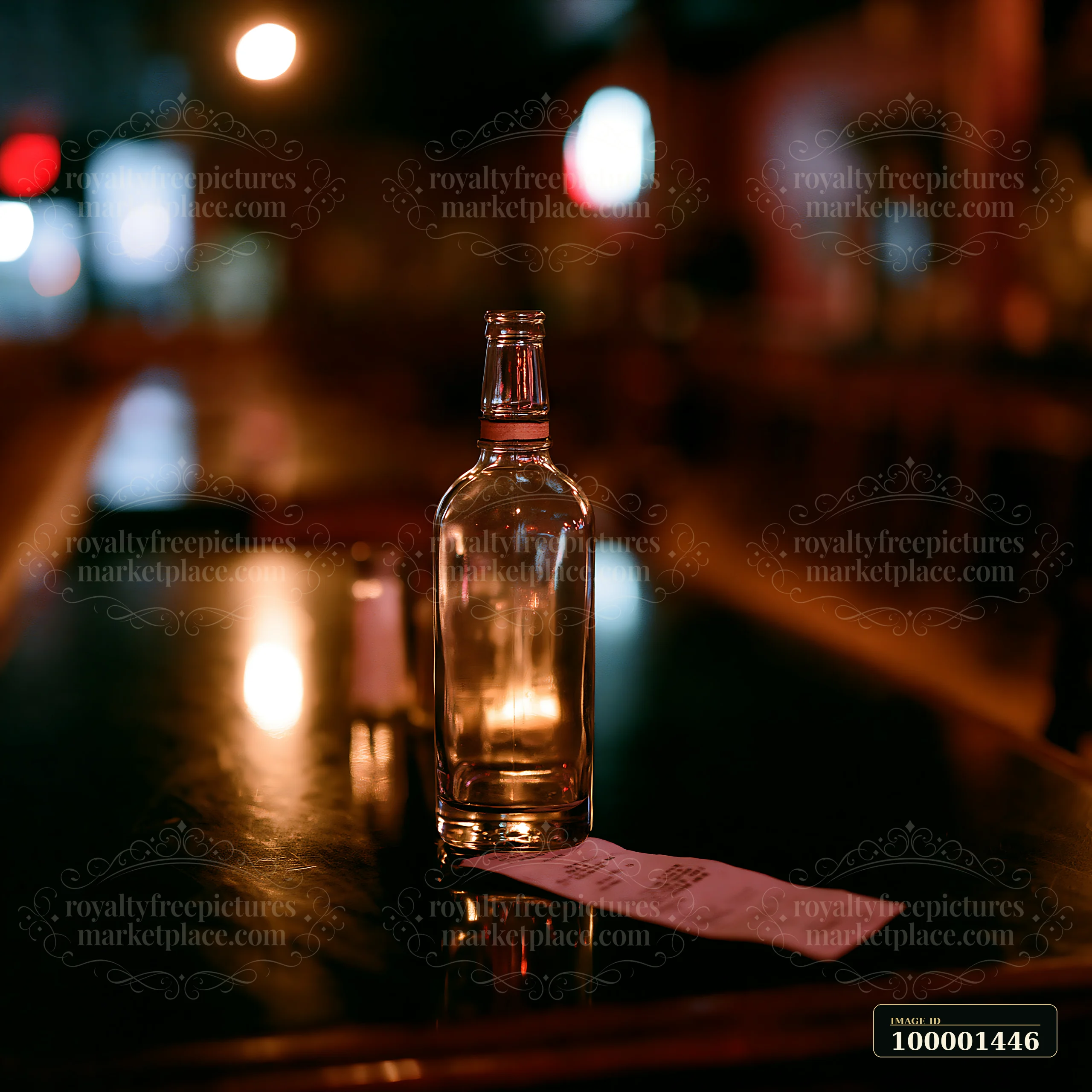 An empty bottle is placed beside a receipt on a table in a dimly lit bar.