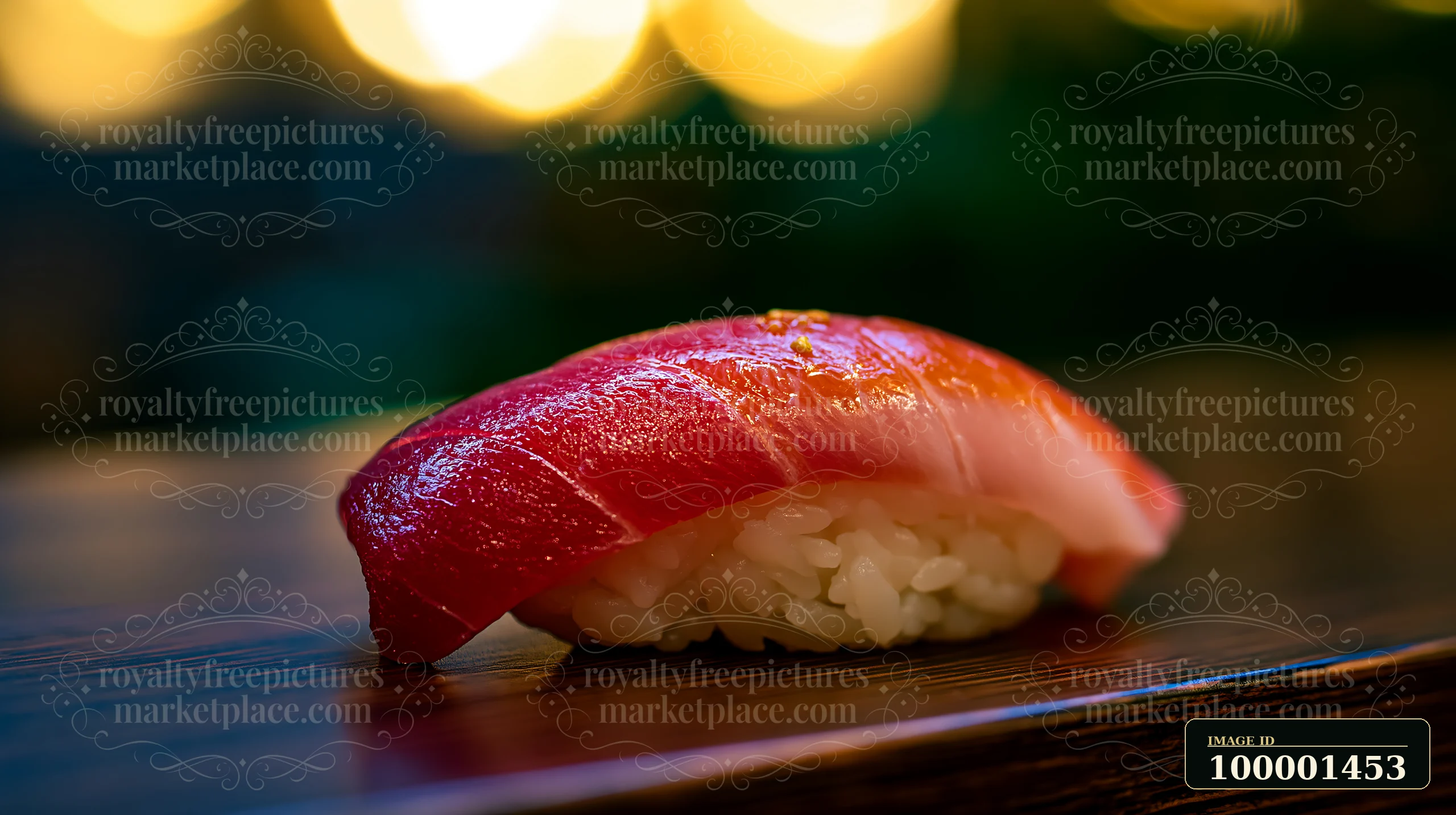 A single sushi piece with colorful fish topping sits on a wooden surface, showcasing a blend of pink and red fish.