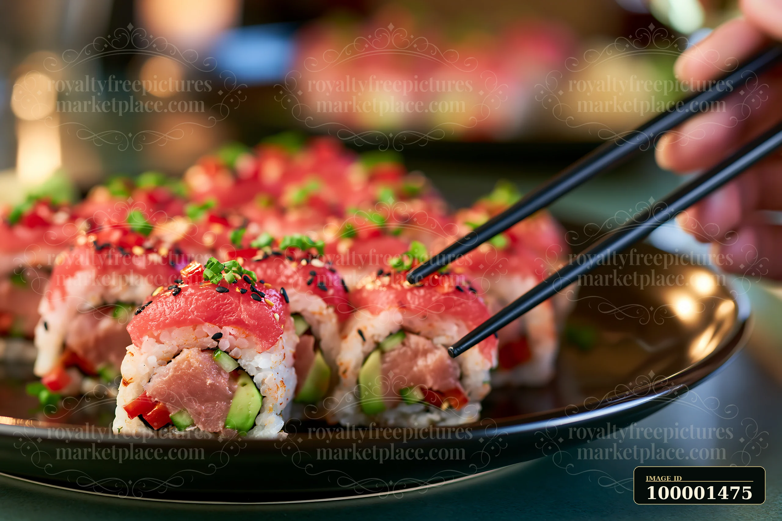 Chopsticks lift a slice of spicy tuna roll adorned with red and green toppings.