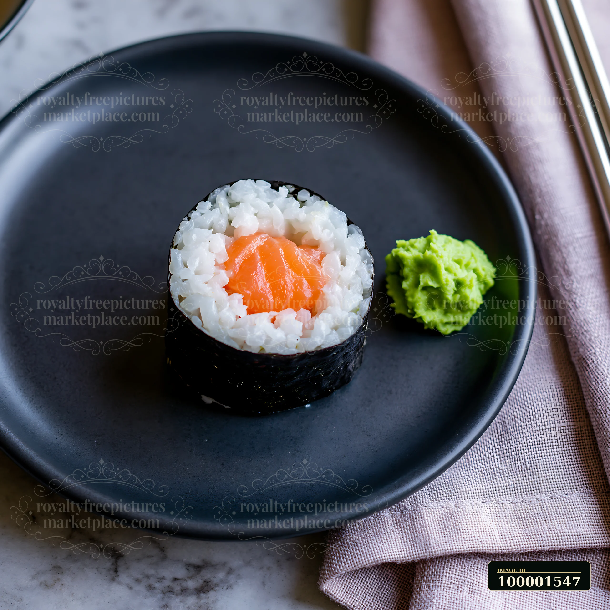 One salmon maki piece with wasabi is served on a dark plate beside a cloth napkin.