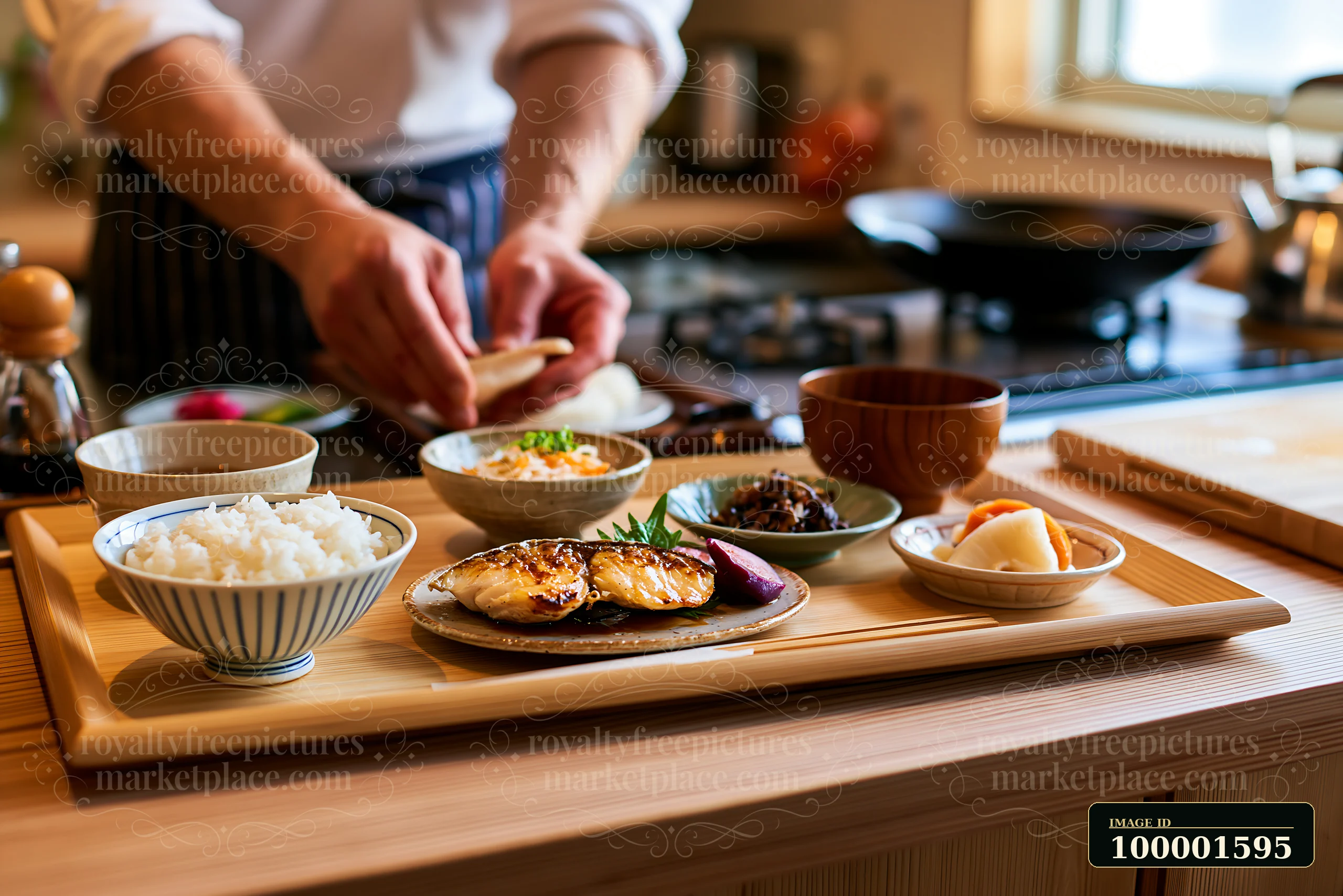 A person prepares a traditional sushi breakfast in Japan with rice, grilled fish, and side dishes.