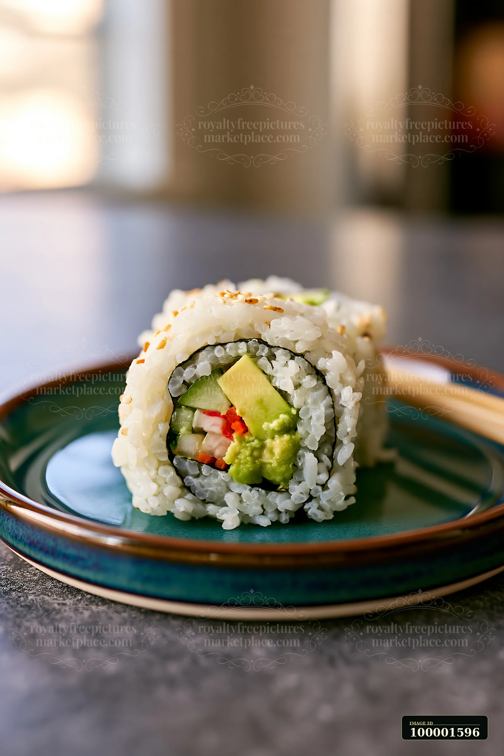 One California roll piece on plate rests on a blue-green dish with chopsticks beside it.
