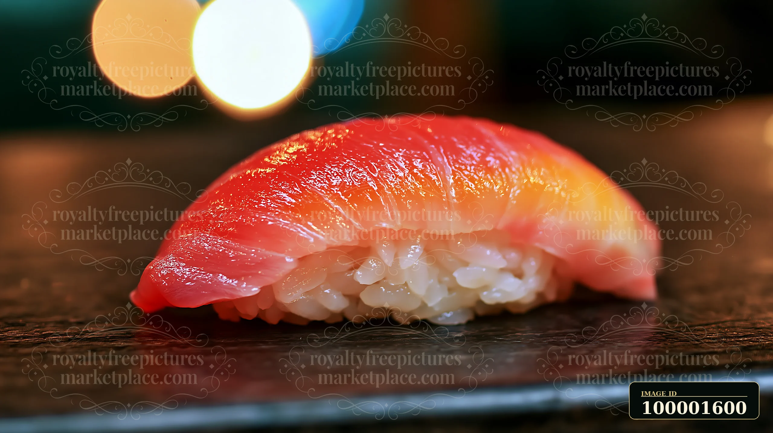 A single sushi piece with colorful fish topping sits on a dark plate.