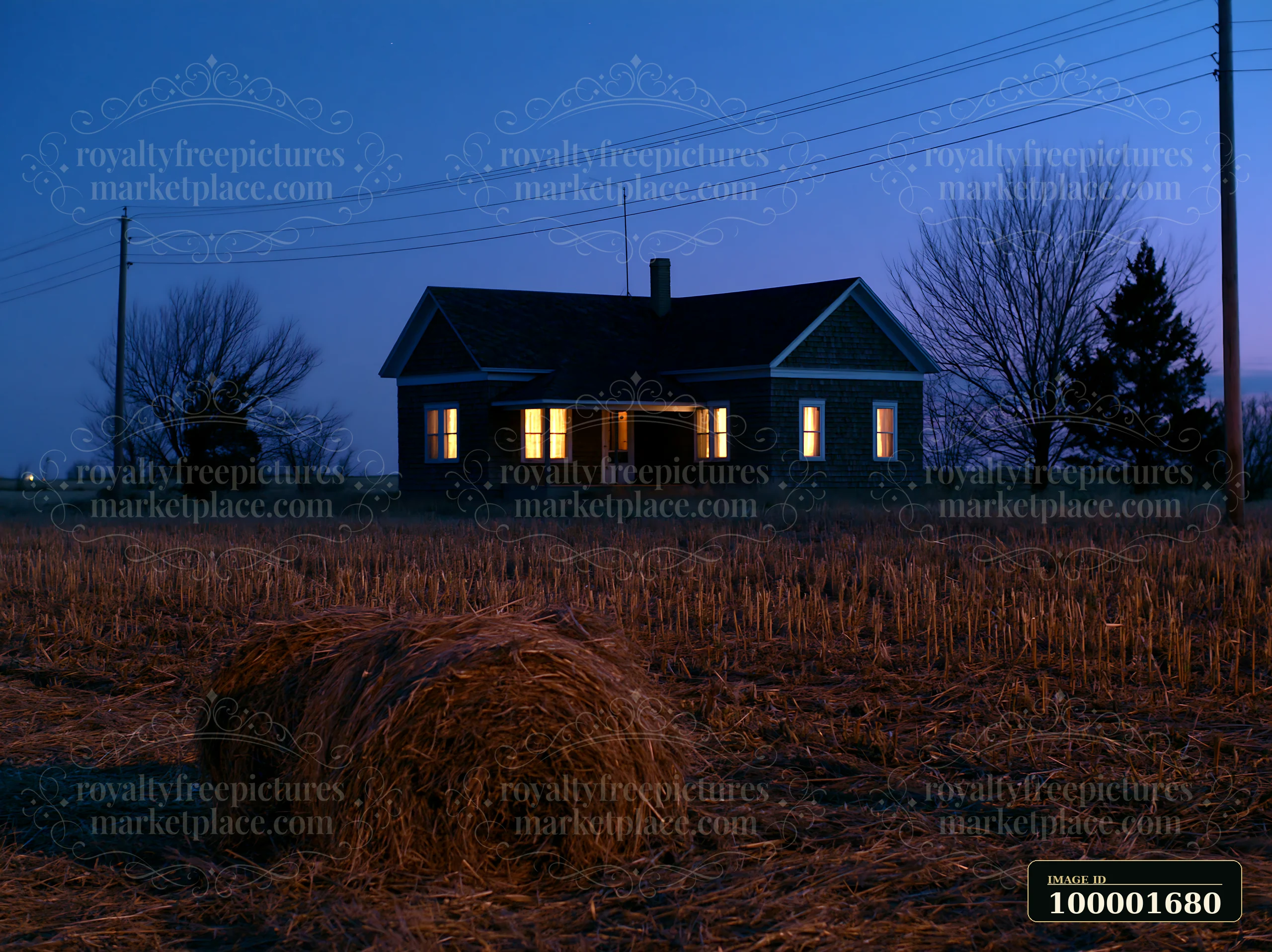 A country home stands alone in the night, with lights glowing from the windows.