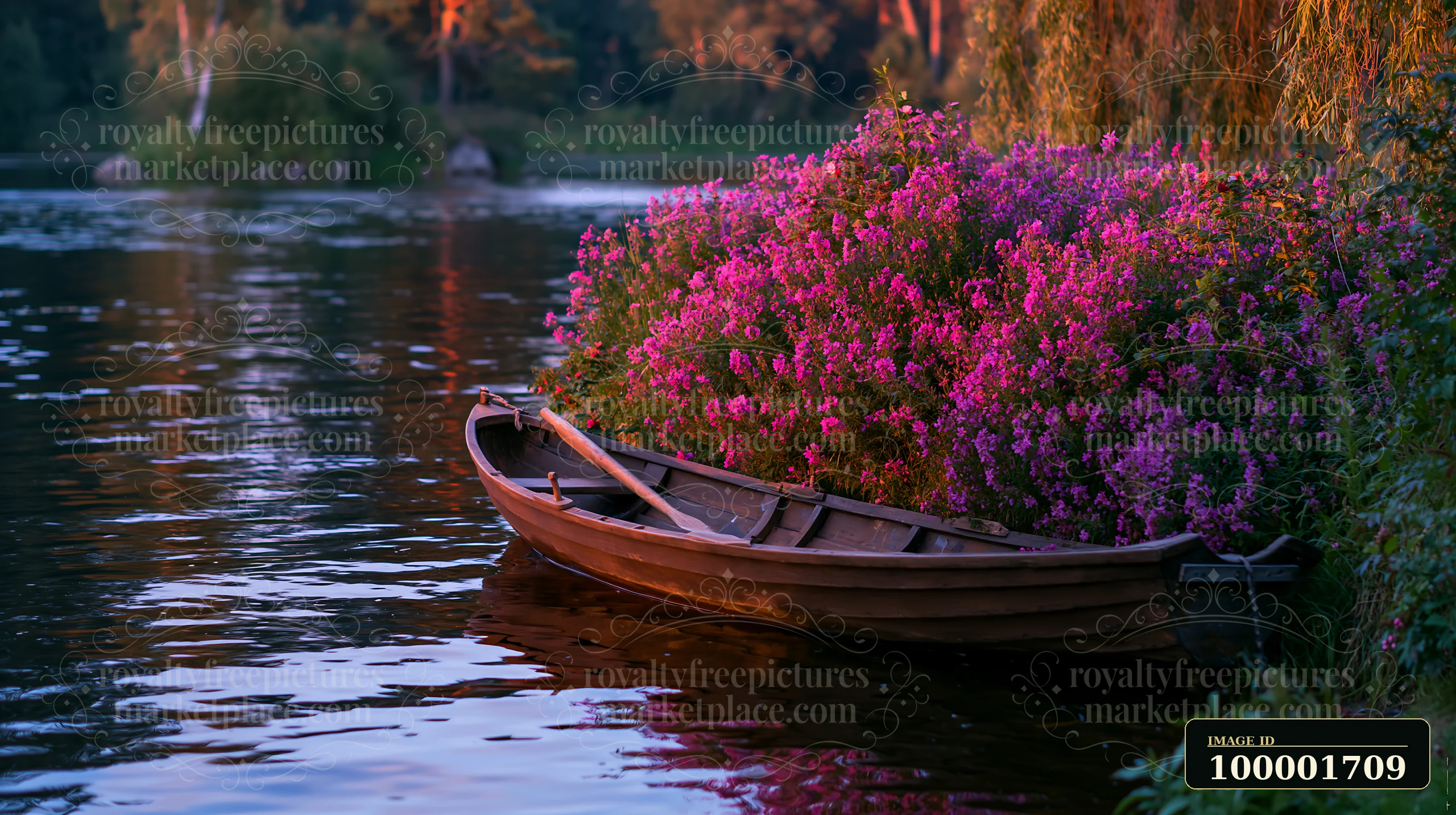 A boat is filled with vibrant flowers and rests by a river, reflecting the golden light of sunset.