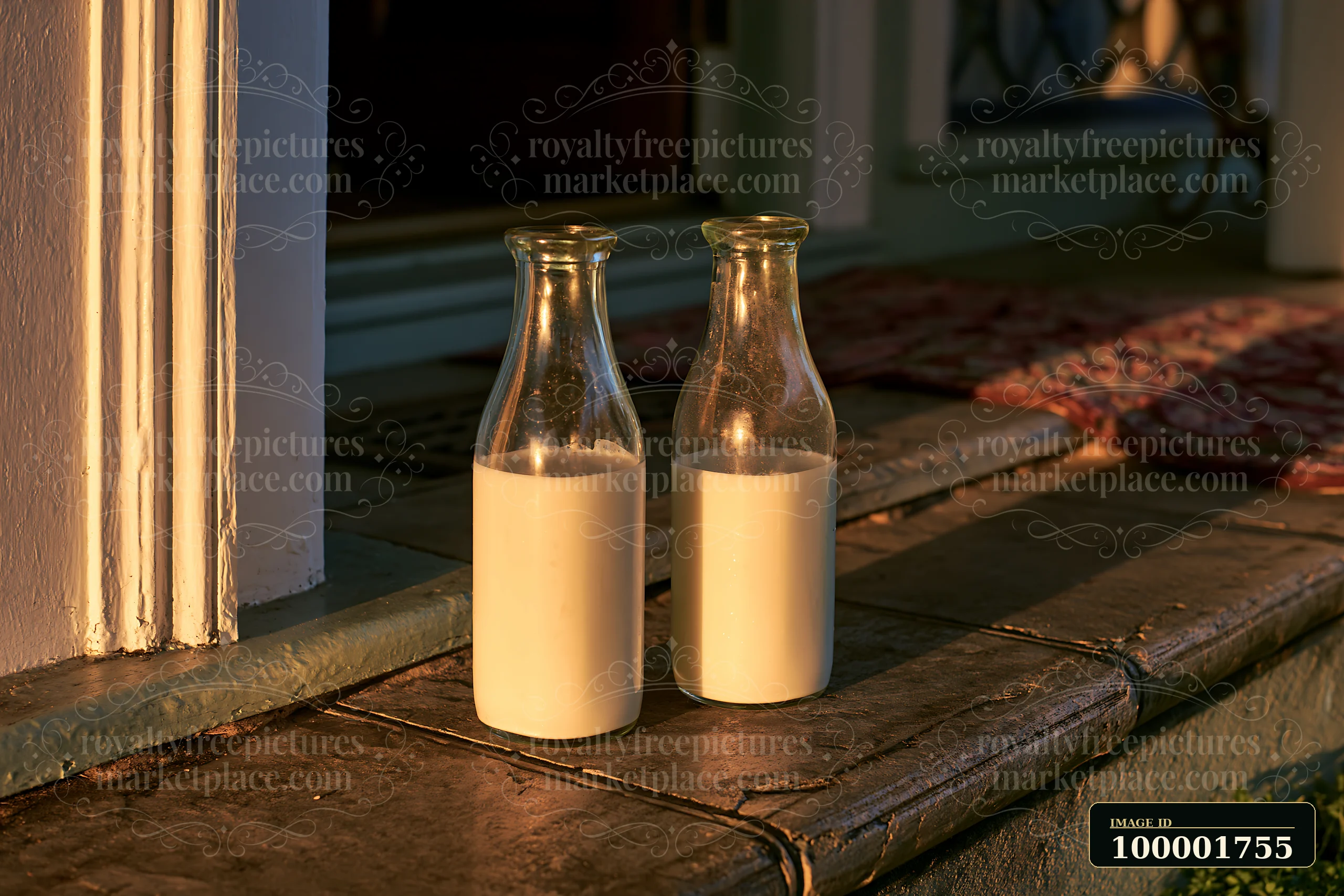 Two glass milk bottles rest on a doorstep as the sun rises, casting warm light on the bottles and the stone surface.
