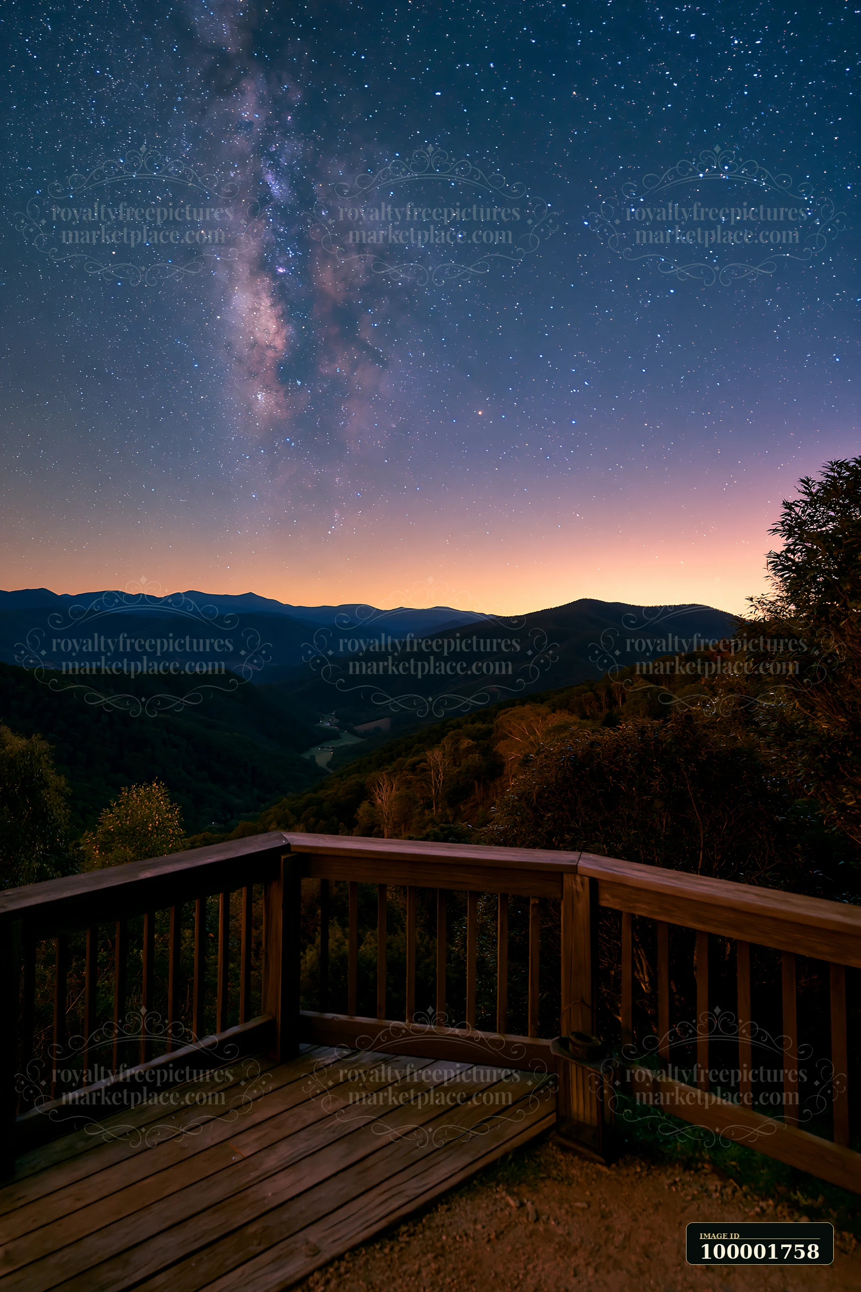 The view shows a starry night above a mountain valley, with a wooden deck in the foreground.
