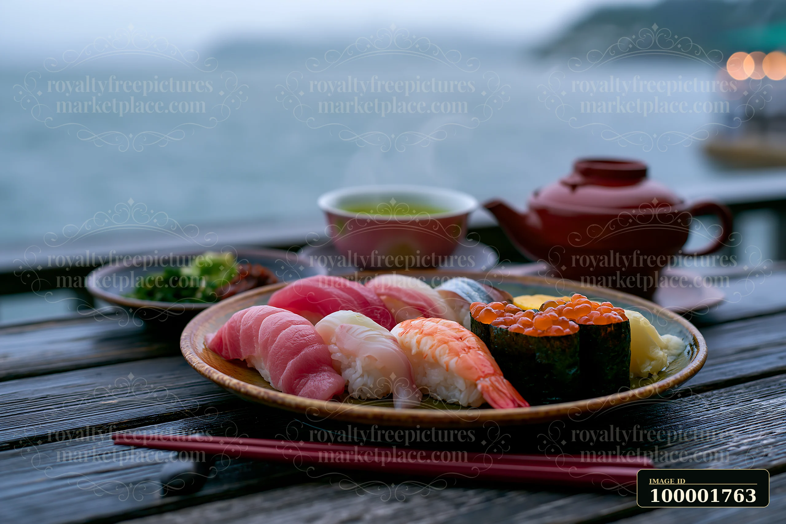 Sushi beside steaming green tea is served on a wooden table next to a calm body of water.