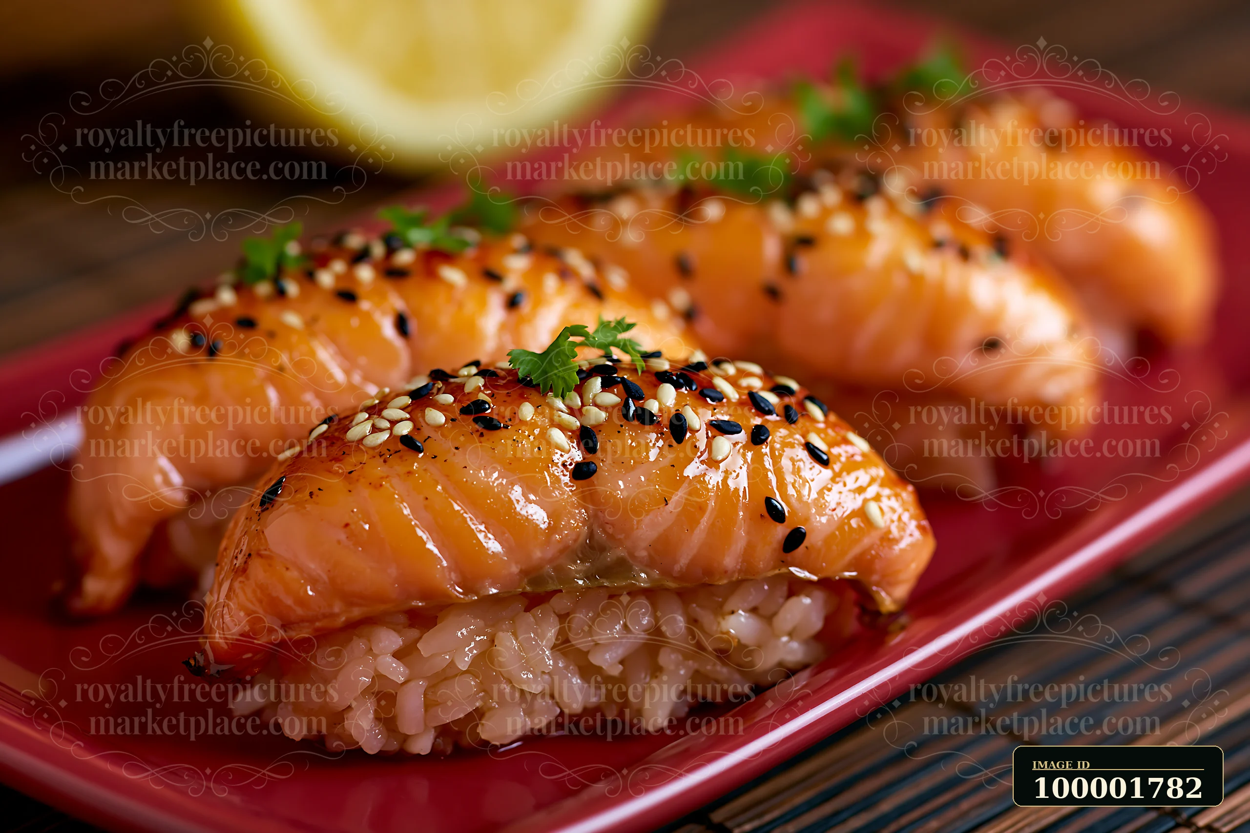 Sushi with lemon garnish close-up shows pieces of salmon sushi arranged on a red plate.