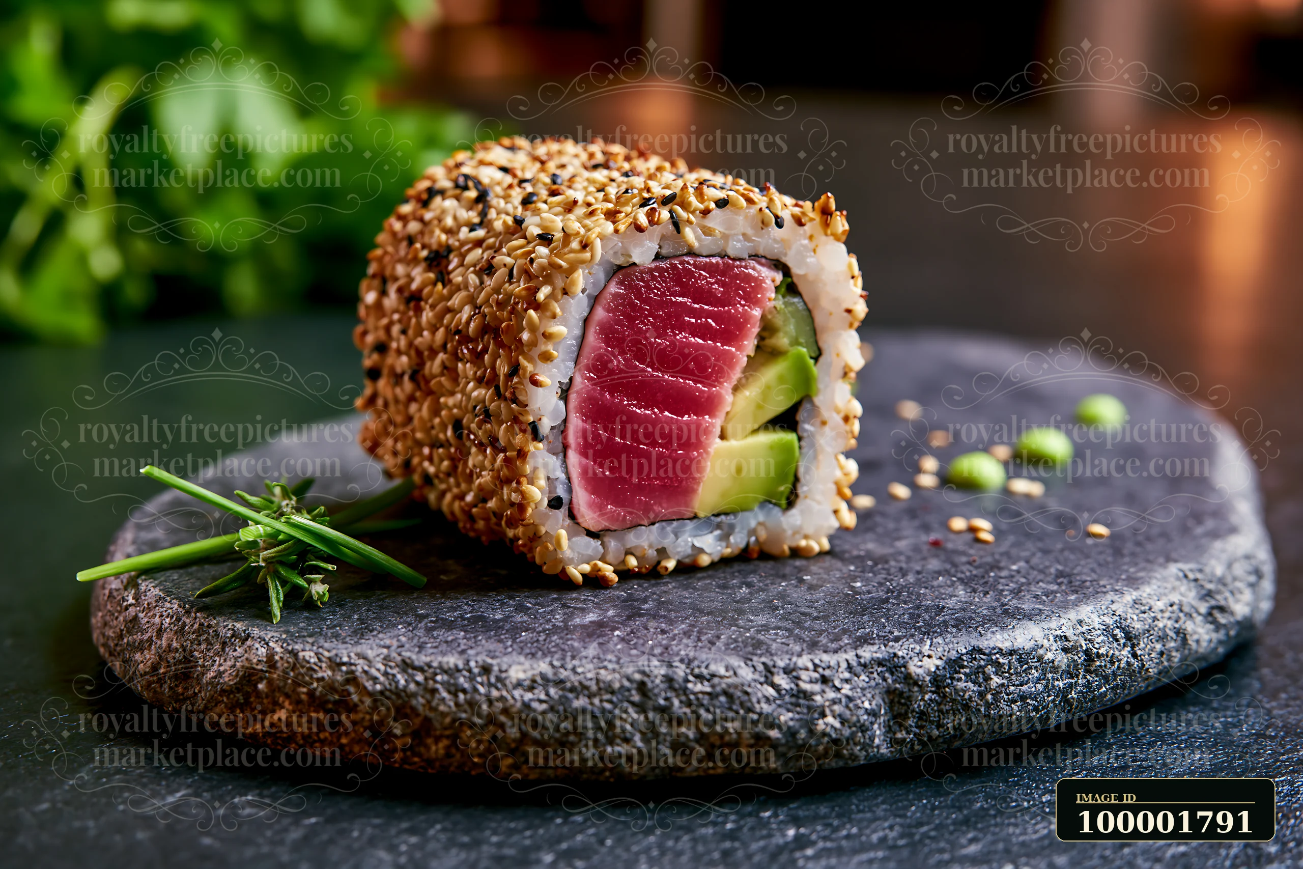 One tuna roll slice with sesame coating rests on a dark stone plate.