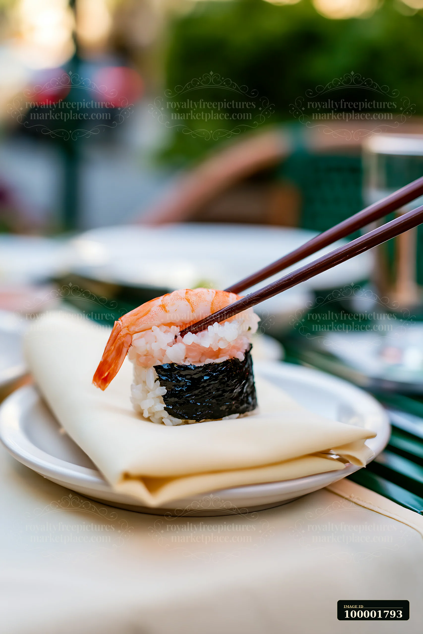 A single sushi piece with chopsticks rests on a white plate at a table in a restaurant.