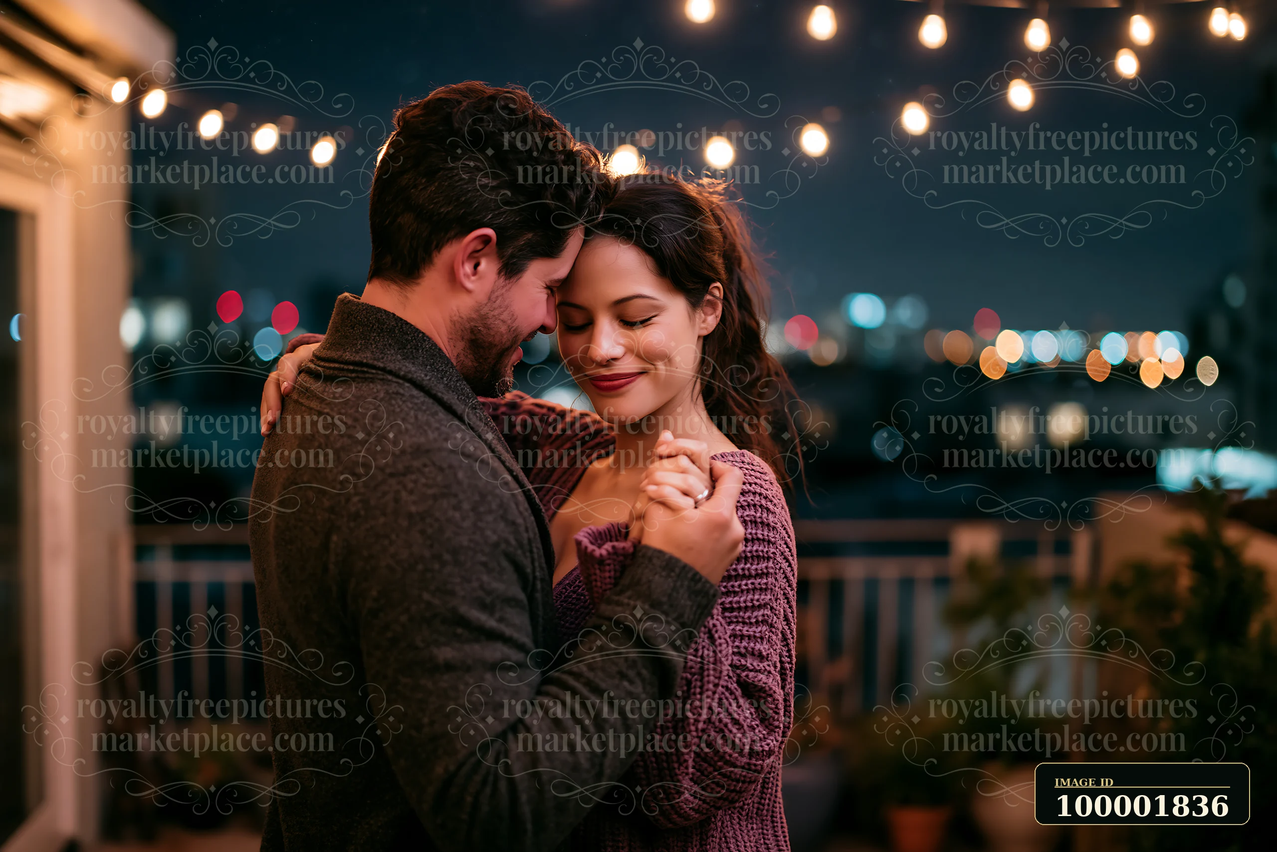 A couple dances closely under string lights on a balcony while city lights glow in the background.