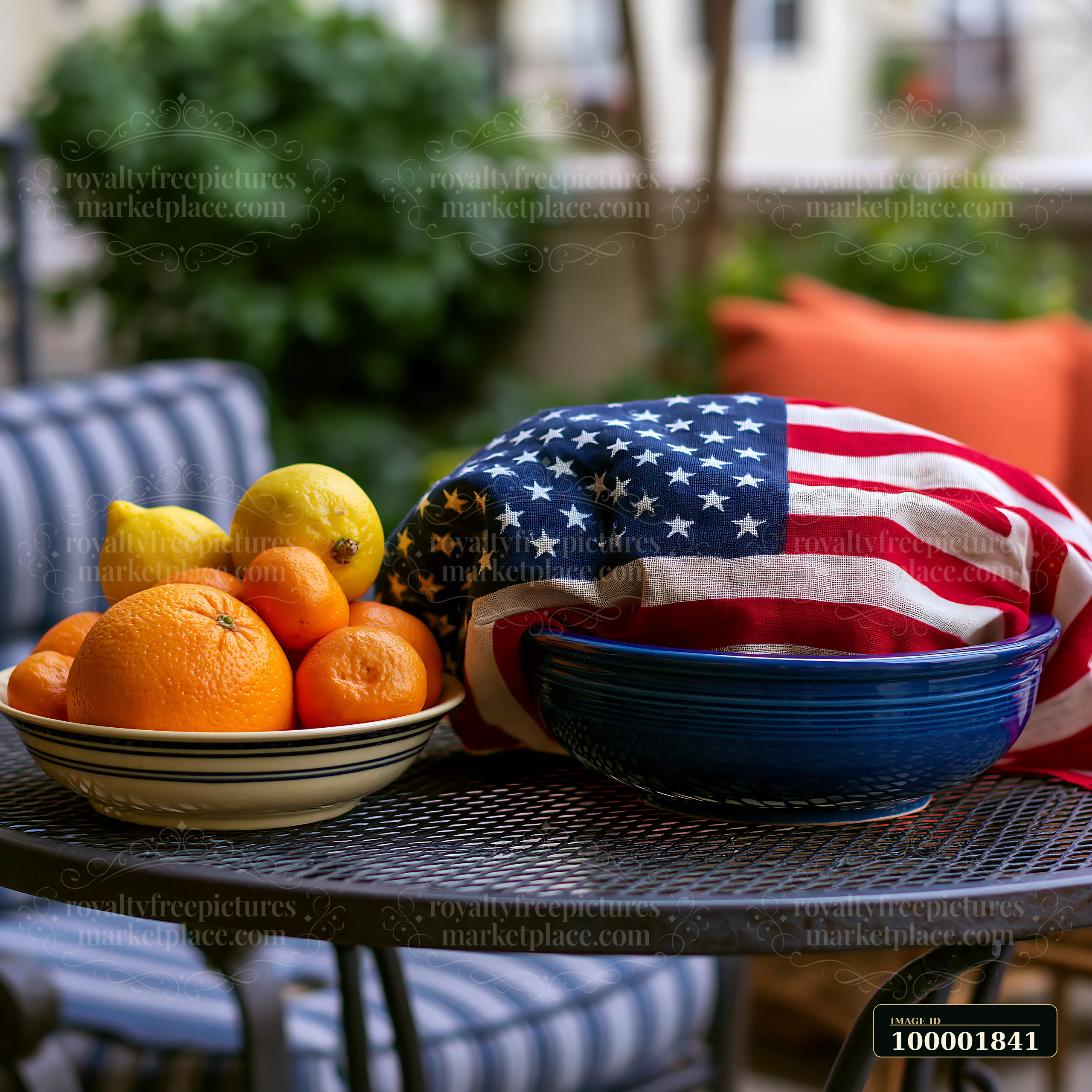 A round bowl of oranges and lemons sits on a table covered by an American flag.