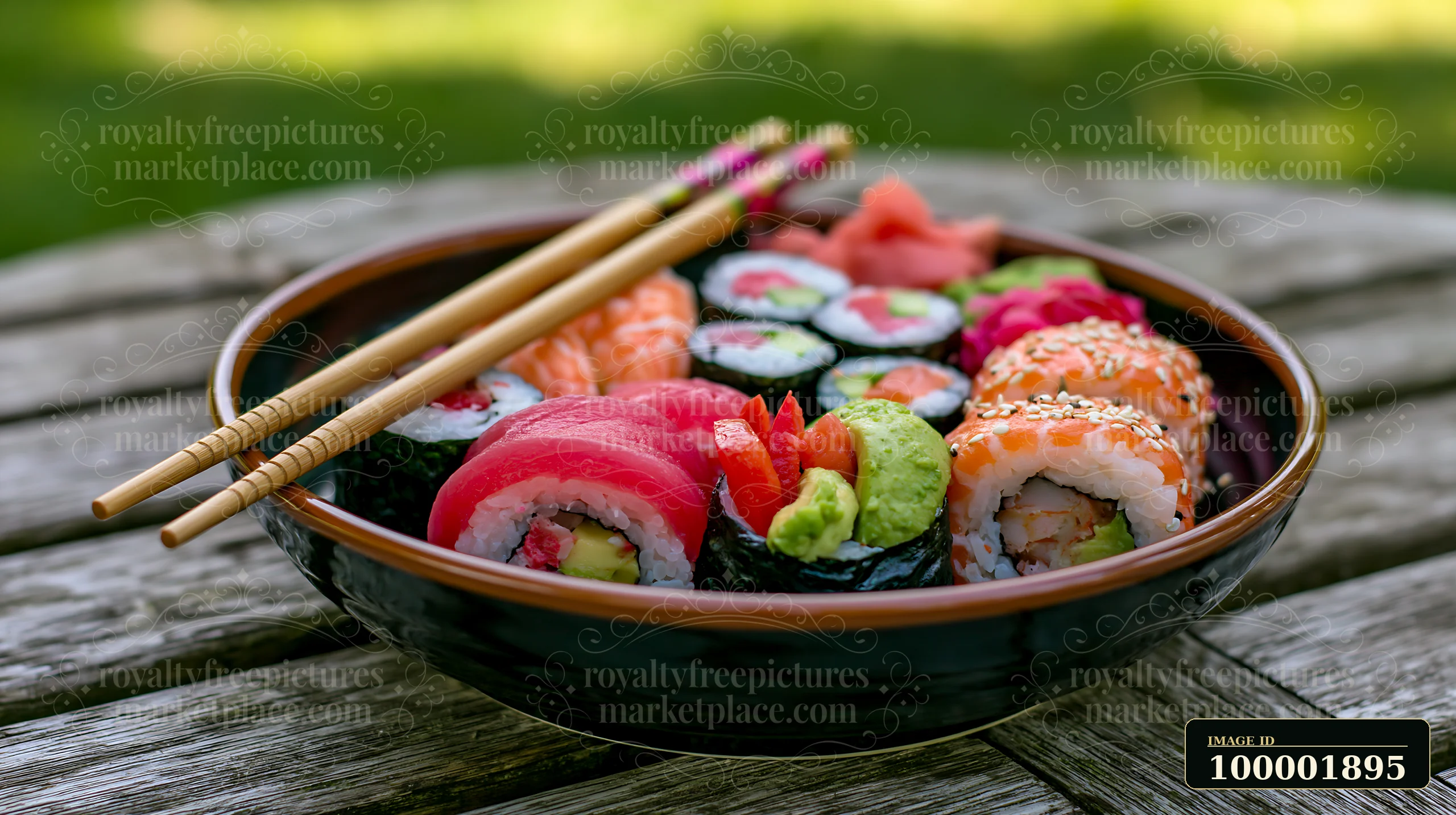 Sushi with chopsticks resting on bowl sits on a wooden table outdoors.