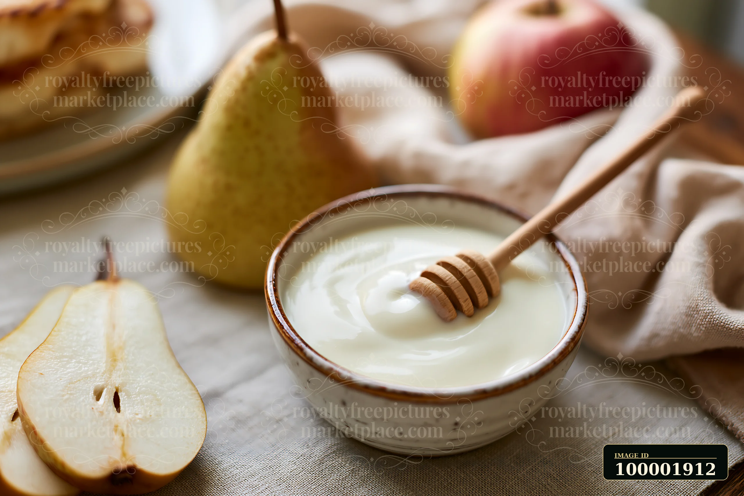Cream dose beside honey dipper is placed on a table with fresh fruit.